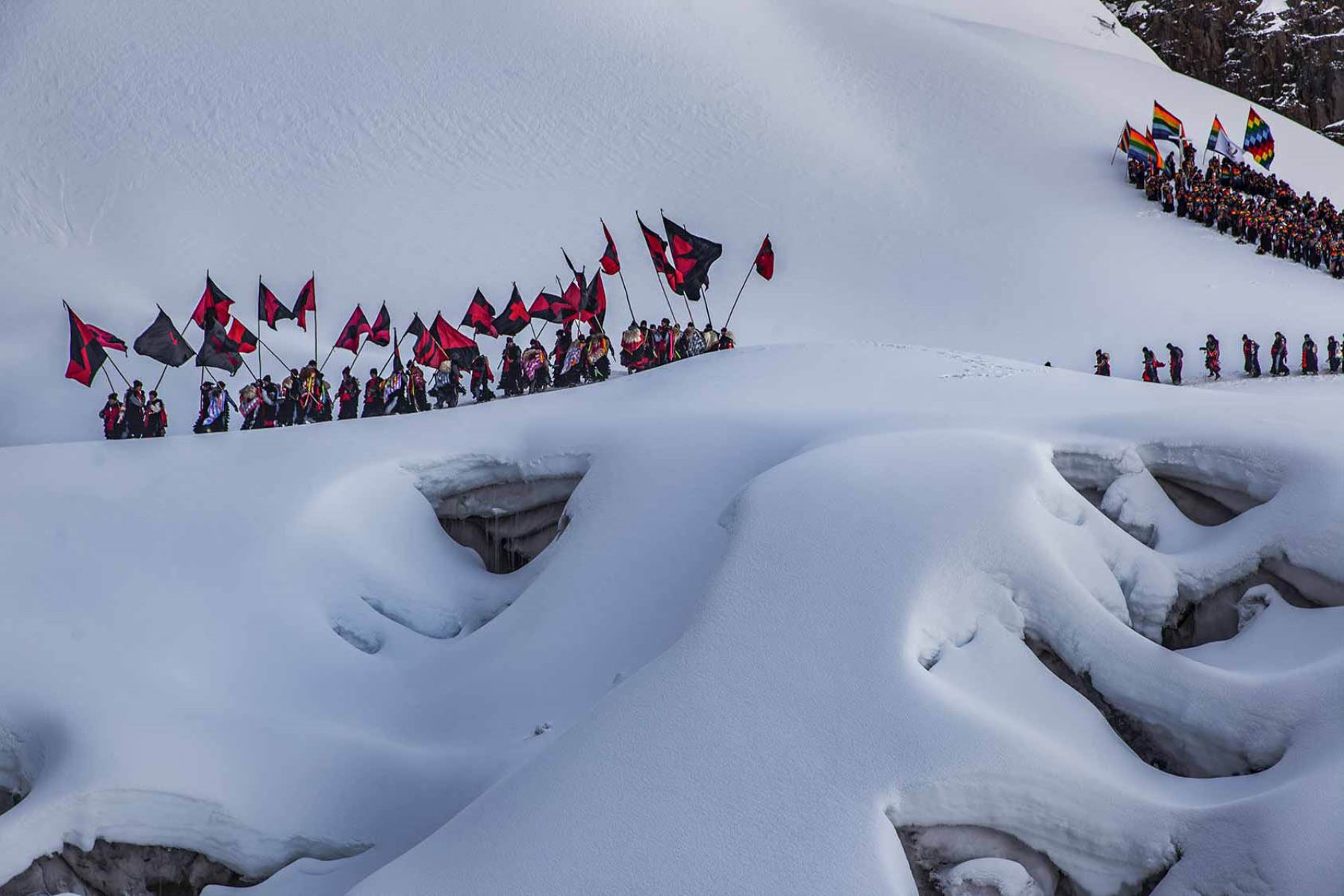 Los Ukukus descienden del nevado. Encabeza la legión una comitiva que danza con banderas.Fotografía del libro, Qoyllurit