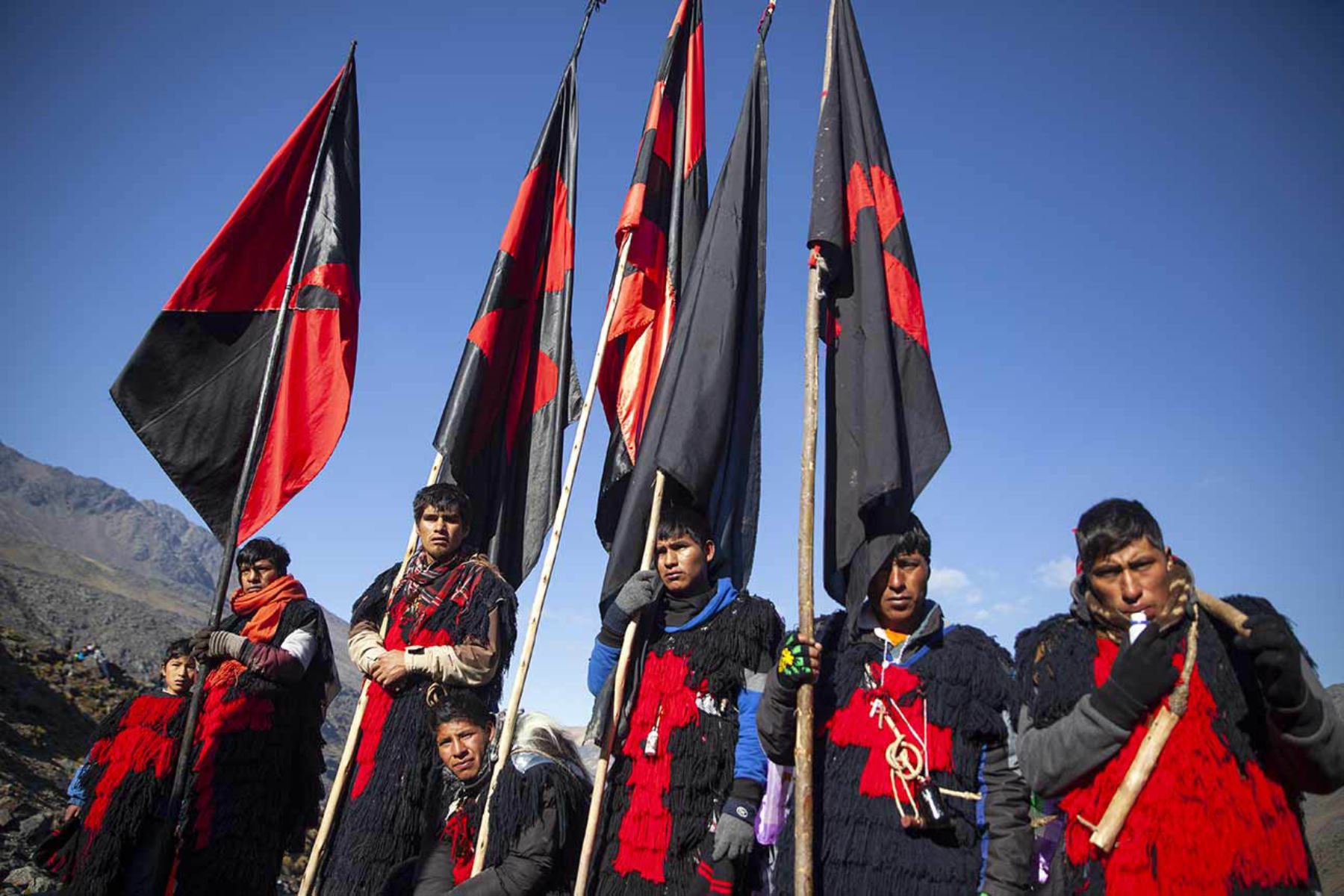 Jóvenes Ukukus en el Santuario sostienen las banderas que identifican a la nación Paucartambo. Fotografía del libro, Qoyllurit