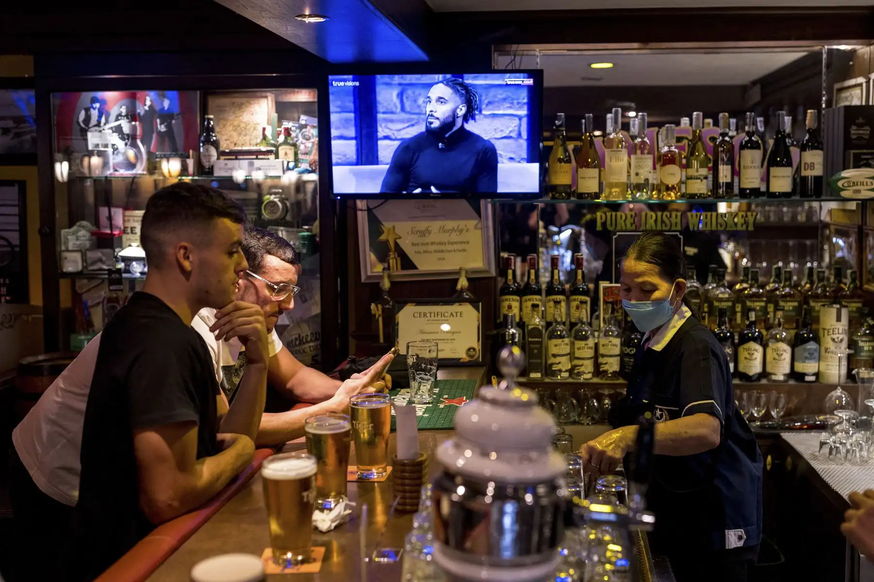 La gente disfruta de una bebida en un bar con la aprobación del gobierno para vender alcohol en medio de las restricciones relacionadas con el coronavirus covid-19 en Bangkok.
Foto: AFP