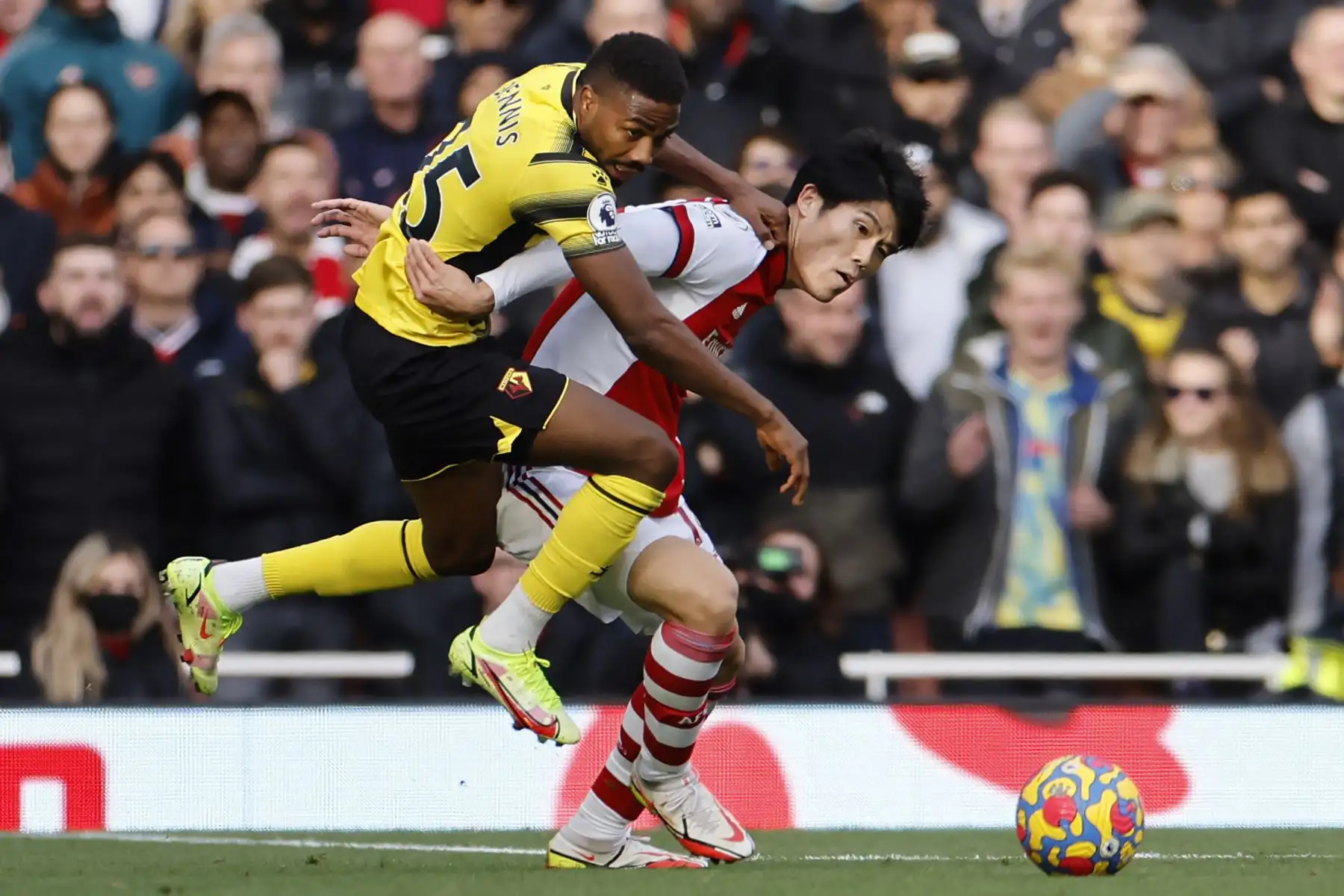 El defensor japonés del Arsenal Takehiro Tomiyasu compite con el delantero nigeriano del Watford Emmanuel Dennis durante el partido de la Premier League. Foto: AFP