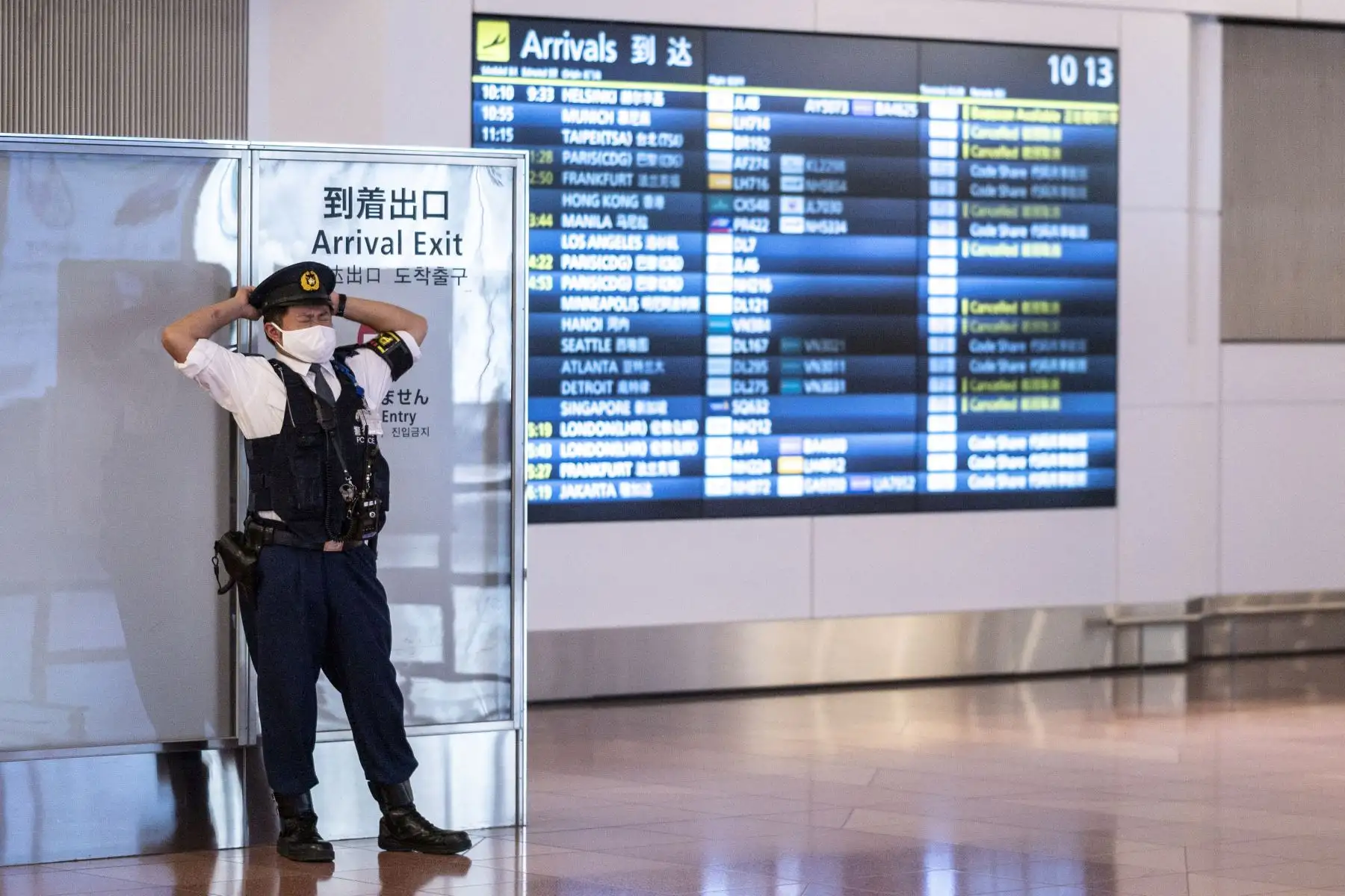 Un oficial de policía se encuentra en la sala de llegadas del aeropuerto de Haneda en Tokio, mientras Japón flexibiliza las reglas fronterizas para permitir visitantes de negocios y estudiantes en medio de la pandemia Covid-19. 
Foto: AFP
