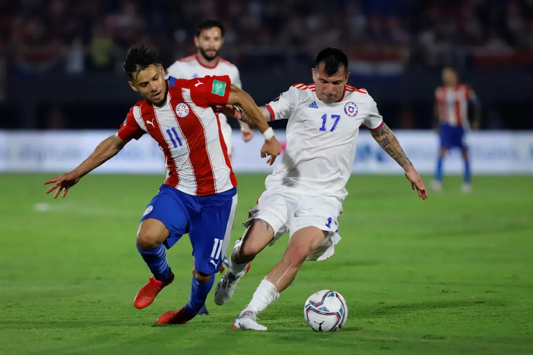 Ángel Romero (i) de Paraguay disputa el balón con Gary Medel de Chile hoy, en un partido de las eliminatorias sudamericanas entre Paraguay y Chile en el estadio Defensores del Chaco en Asunción (Paraguay). EFE/Nathalia Aguilar