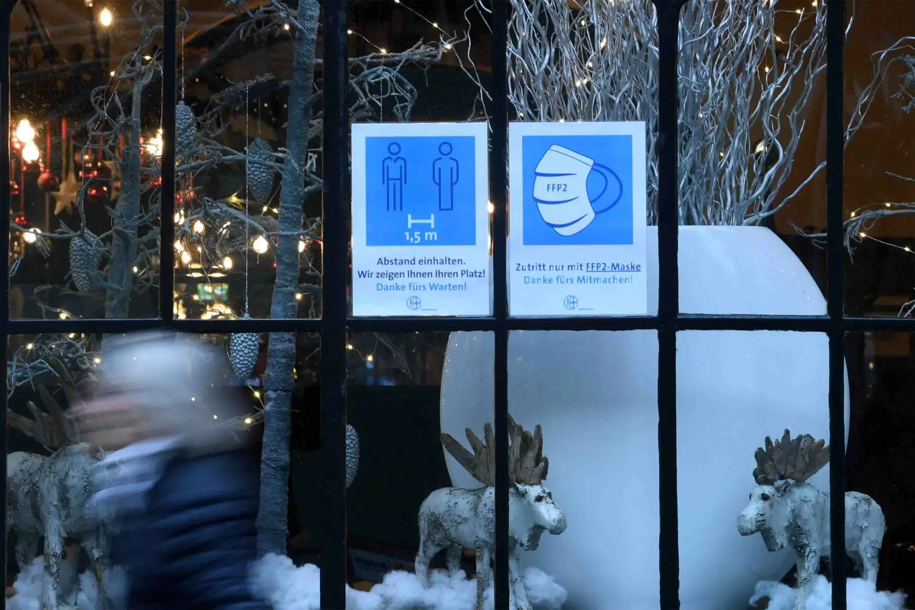 Un letrero que informa a los viajeros que deben cubrirse la boca y la nariz con una máscara FFP2 y respetar el distanciamiento social se ve en la ventana de un restaurante decorado con decoración navideña en la ciudad de Múnich, en el sur de Alemania.
Foto: AFP