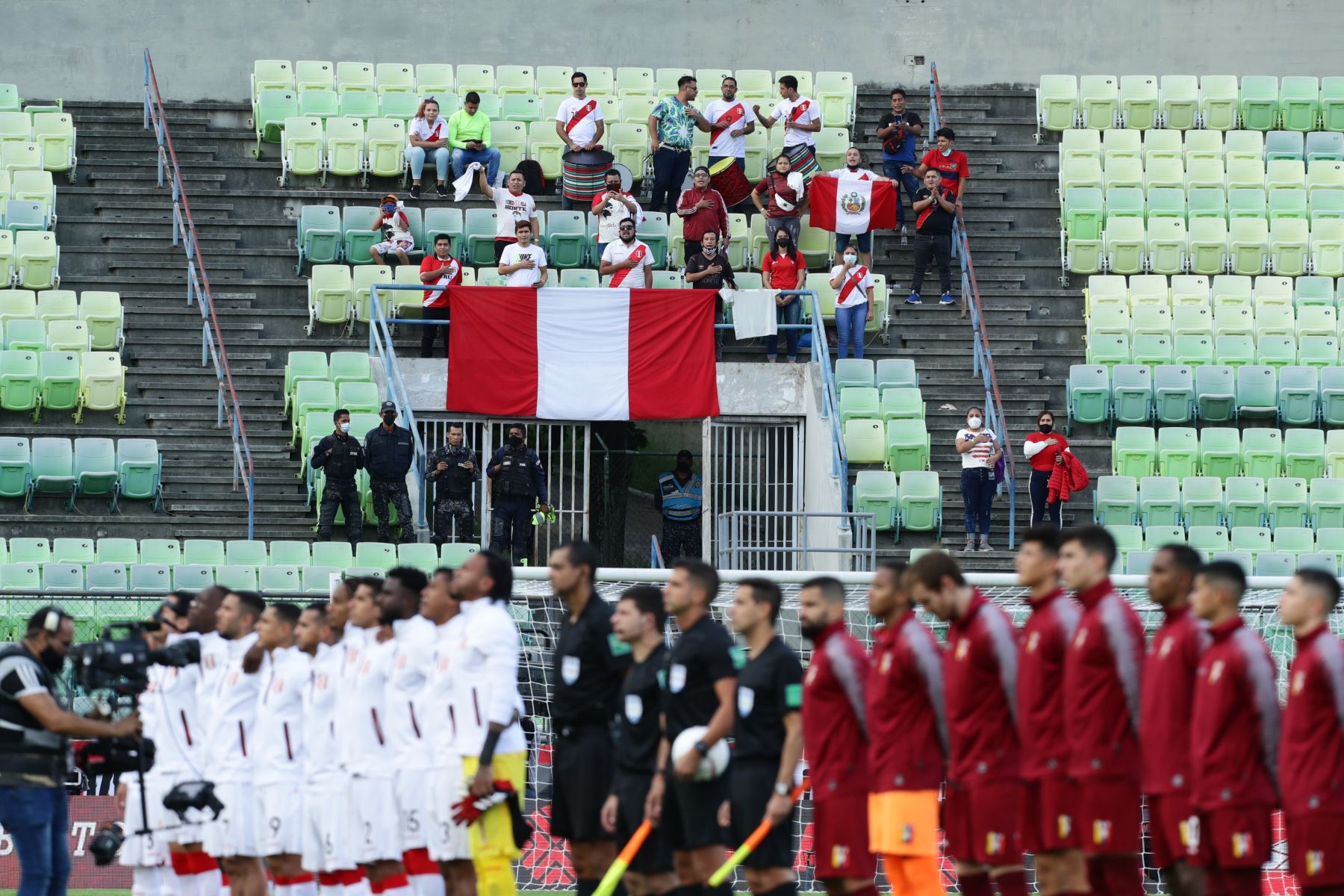 Aficionados de Perú cantan el himno nacional hoy, en un partido de las eliminatorias sudamericanas para el Mundial de Catar 2022 entre Venezuela y Perú en el estadio Olímpico UCV en Caracas (Venezuela). EFE/Rayner Peña