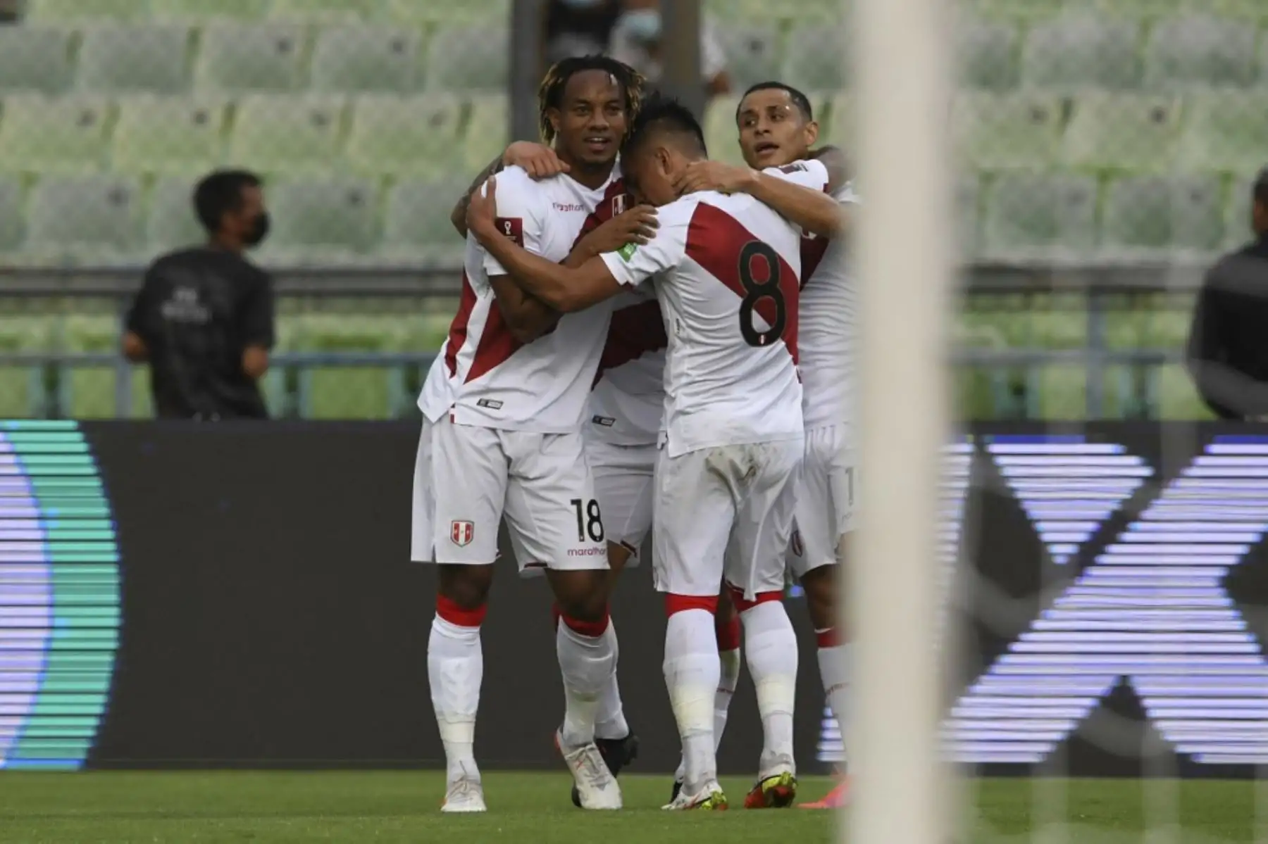 El peruano Gianluca Lapadula (invisible) celebra con sus compañeros Andre Carrillo (L), Christian Cueva (C) y Yoshimar Yotun (R) después de anotar contra Venezuela durante su partido de clasificación sudamericano para la Copa Mundial de la FIFA Qatar 2022 en el Estadio Olímpico de la UCV en Caracas el 16 de noviembre de 2021. Foto: AFP