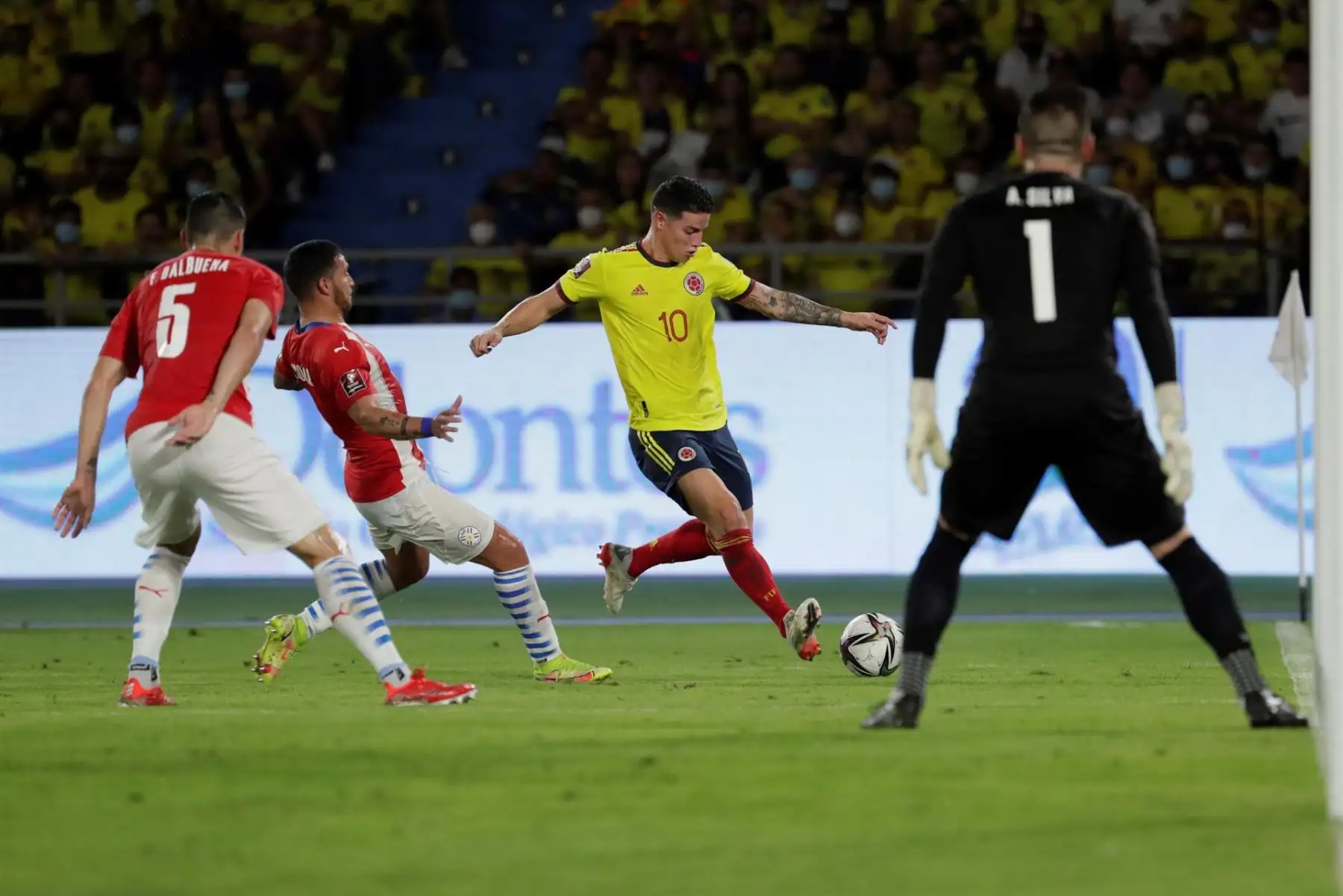 James Rodríguez (c) Colombia enfrenta al arquero Antony Silva de Paraguay hoy, antes de un partido de las eliminatorias sudamericanas para el Mundial de Catar 2022 entre Colombia y Paraguay en el estadio Metropolitano en Barranquilla (Colombia). EFE/Carlos Ortega