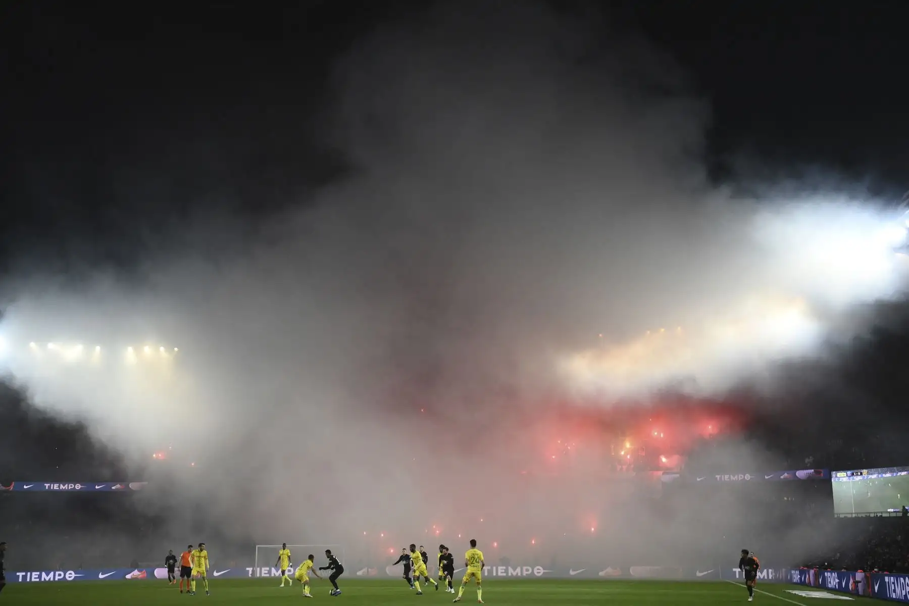 Los aficionados encienden bengalas rojas mientras muestran durante el partido de de la liga francesa L1 entre Paris-Saint Germain (PSG) y FC Nantes, en el estadio Parque de los Príncipes. Foto: AFP