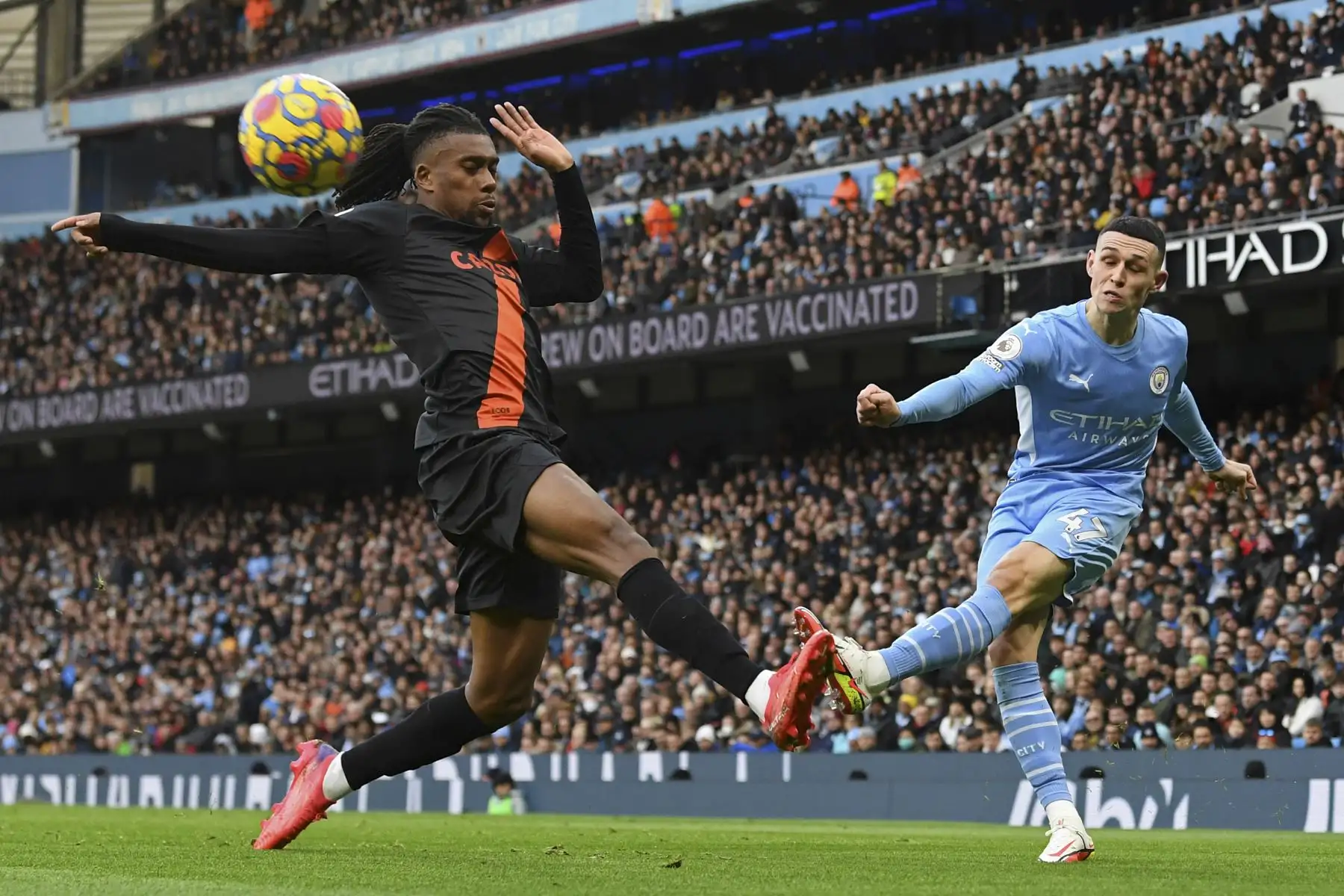 El centrocampista nigeriano del Everton Alex Iwobi  intenta bloquear un centro del mediocampista inglés del Manchester City Phil Foden durante el partido de la Premier League. Foto: AFP