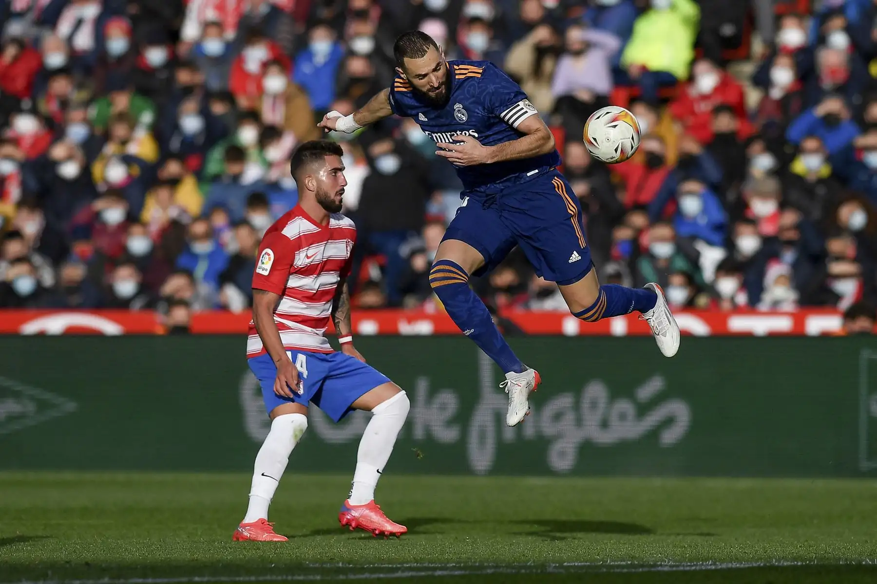 El centrocampista español del Granada Monchu lucha por el balón con el delantero francés del Real Madrid Karim Benzema durante el partido de la Liga española. Foto: AFP