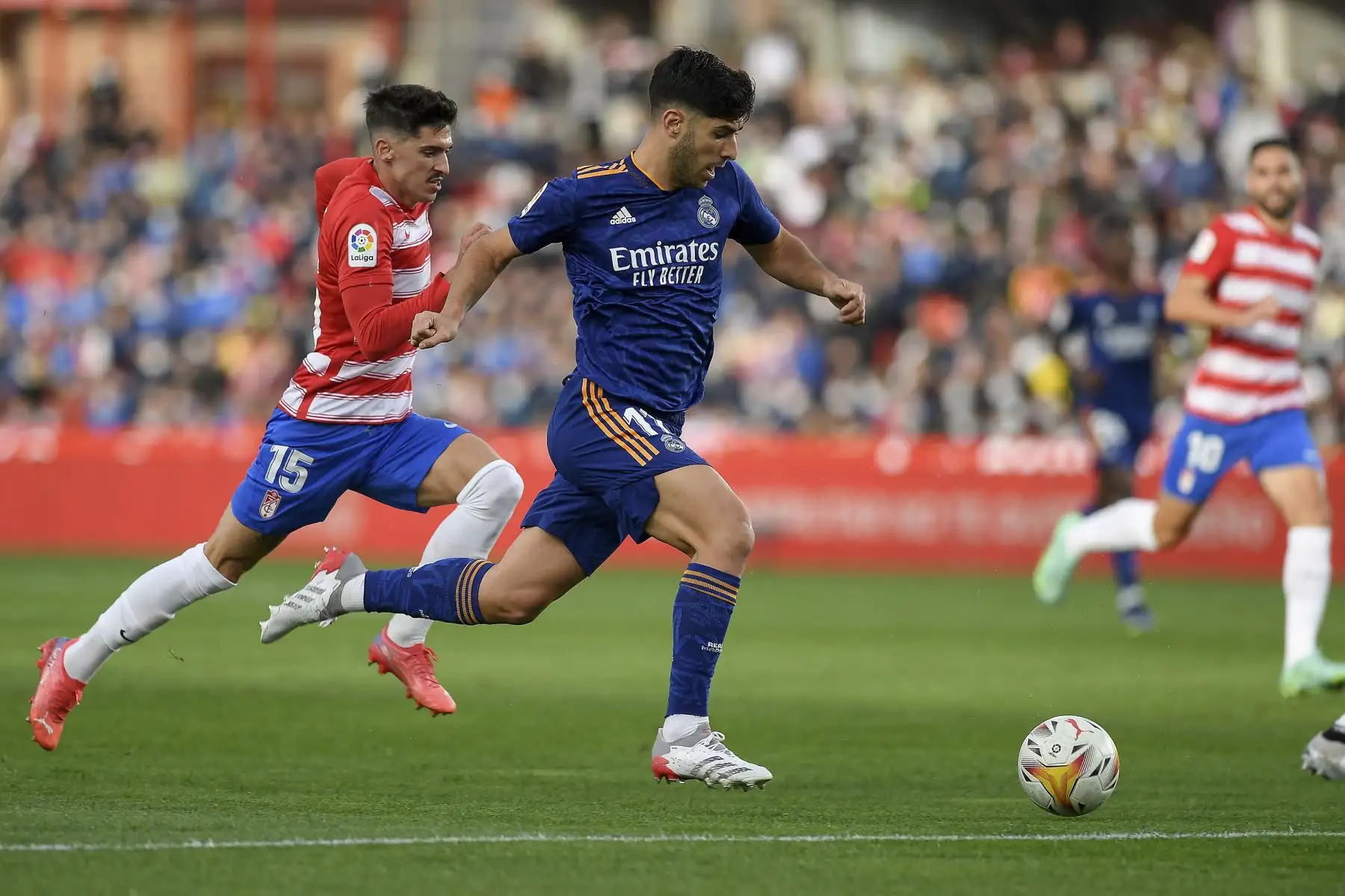 El defensa español del Granada Carlos Neva pelea por el balón con el centrocampista español del Real Madrid Marco Asensio durante el partido de la Liga española. Foto: AFP