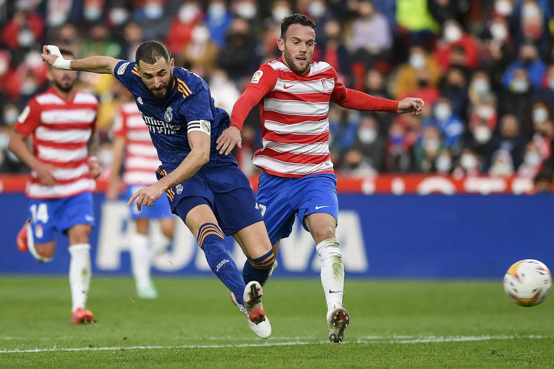 El delantero francés del Real Madrid, Karim Benzema, lucha por el balón con el defensor español del Granada, Quini, durante el partido de la Liga española. Foto: AFP