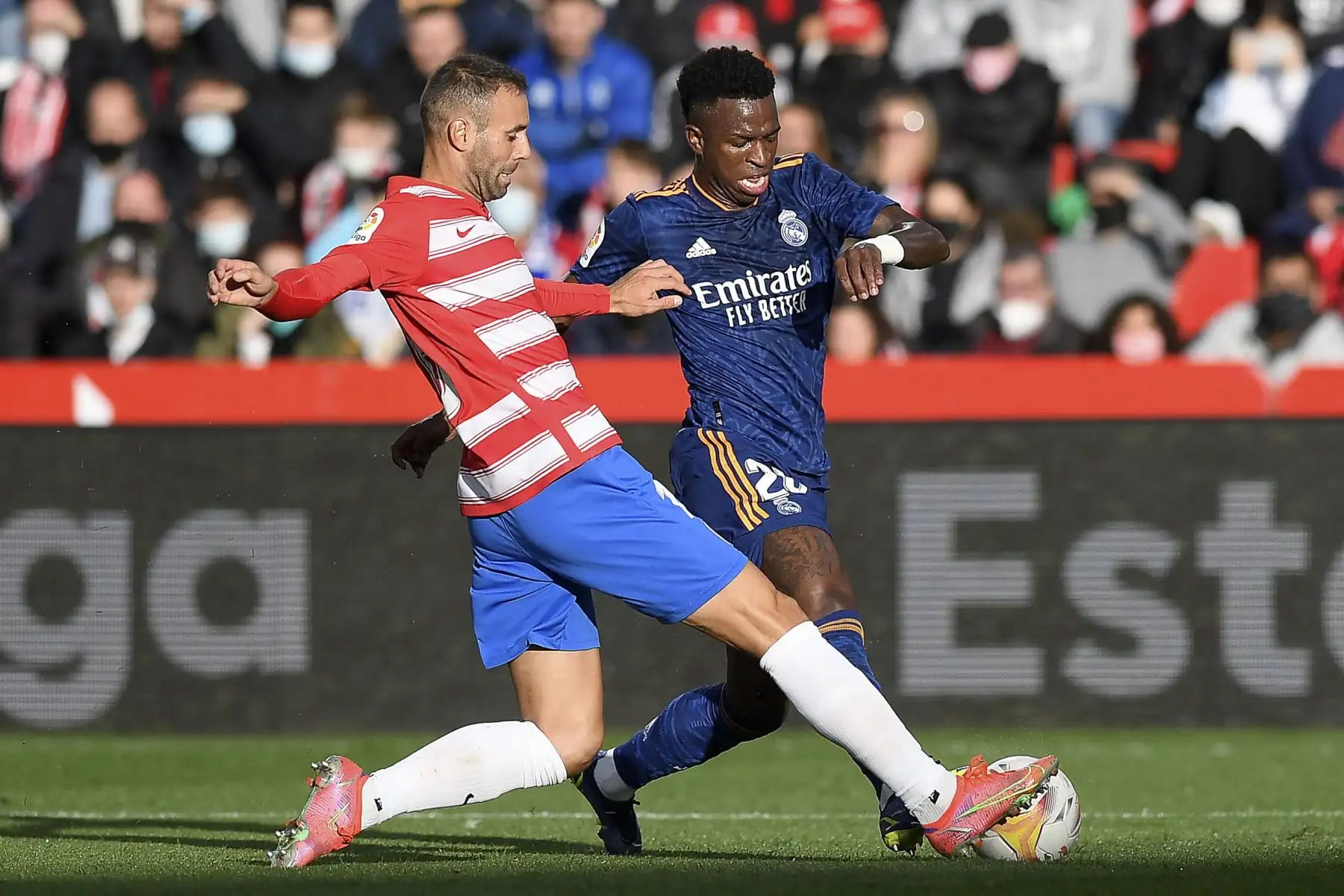 El defensa español del Granada Víctor Díaz pelea por el balón con el delantero brasileño del Real Madrid Vinicius Junior durante el partido de la Liga española. Foto: AFP