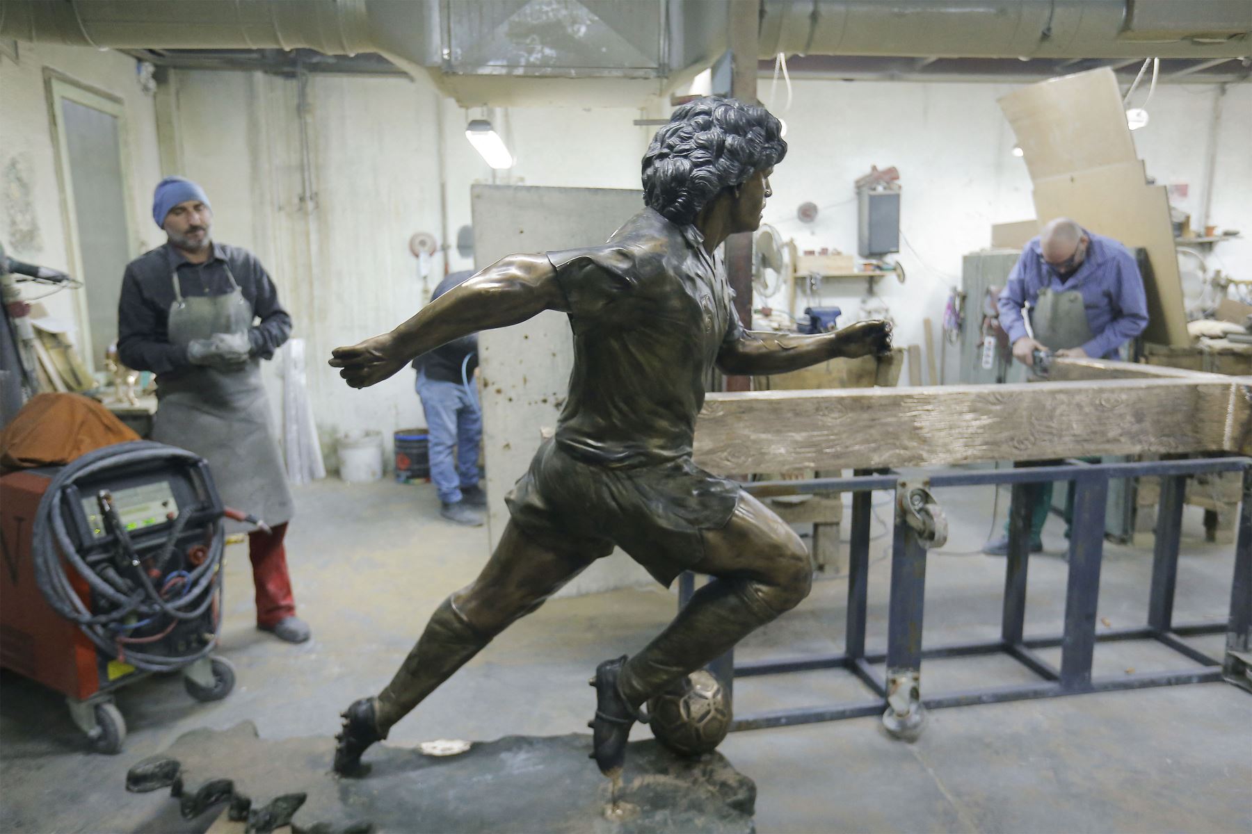 Una estatua de bronce de tamaño natural de la leyenda del fútbol argentino Diego Armando Maradona se muestra en el estudio del escultor italiano Domenico en Nápoles. 
Foto: AFP