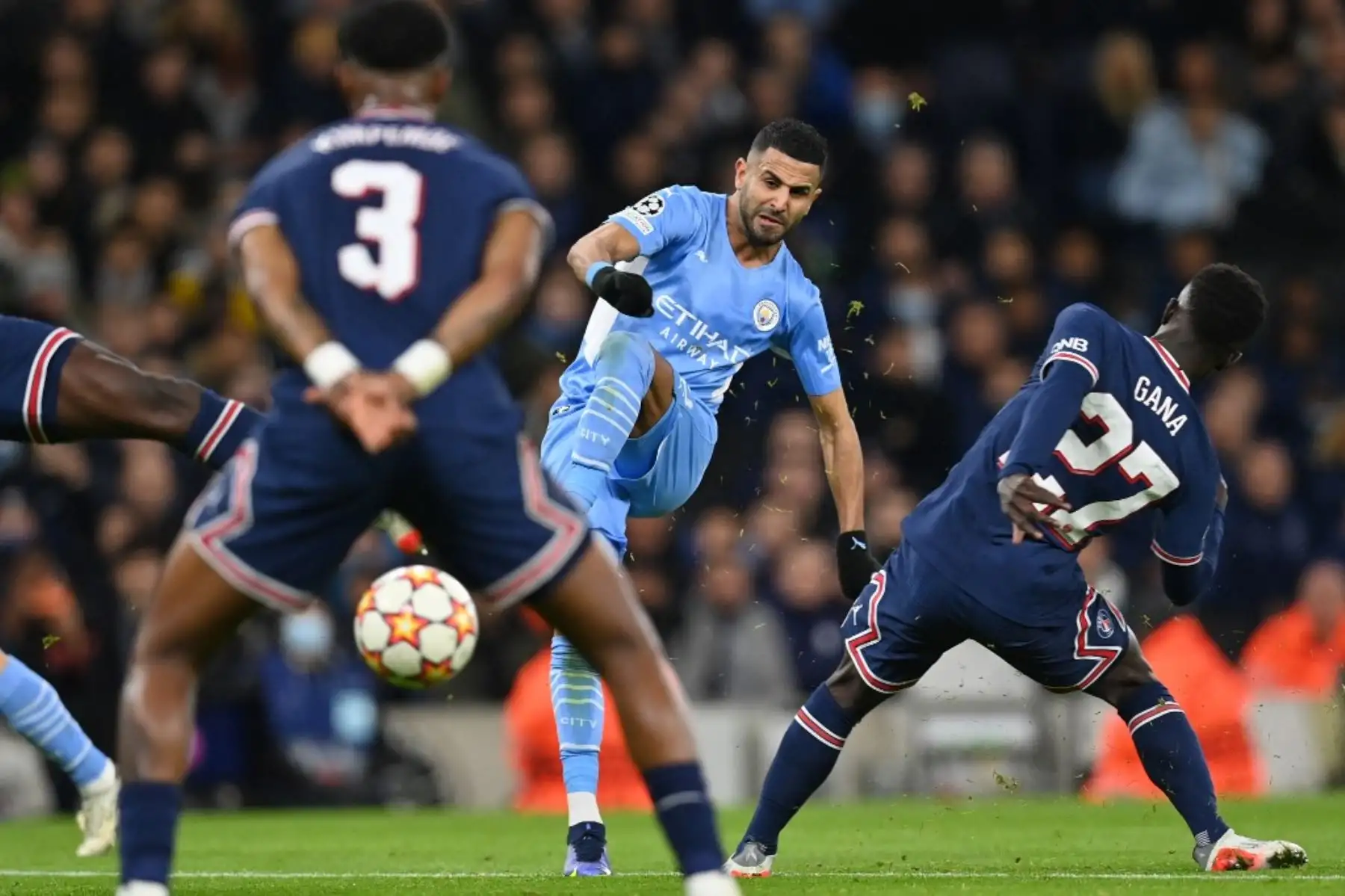 El centrocampista argelino del Manchester City, Riyad Mahrez (C), tiene un disparo fallido durante el partido de fútbol del Grupo A de la Liga de Campeones de la UEFA entre el Manchester City y el Paris Saint-Germain en el Estadio Etihad en Manchester, noroeste de Inglaterra, el 24 de noviembre de 2021. Foto: AFP