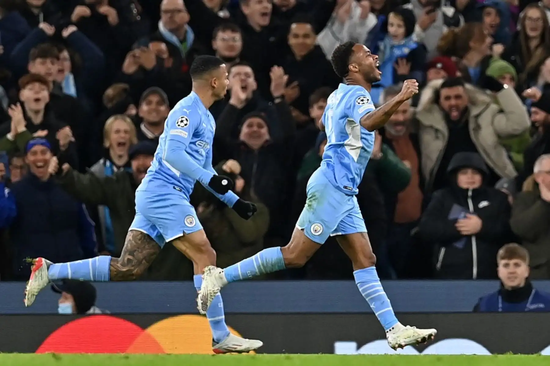 El centrocampista inglés del Manchester City Raheem Sterling (R) celebra tras anotar su primer gol durante el partido de fútbol del Grupo A de la Liga de Campeones de la UEFA entre el Manchester City y el Paris Saint-Germain en el Etihad Stadium de Manchester, noroeste de Inglaterra, el 24 de noviembre de 2021. Foto: AFP