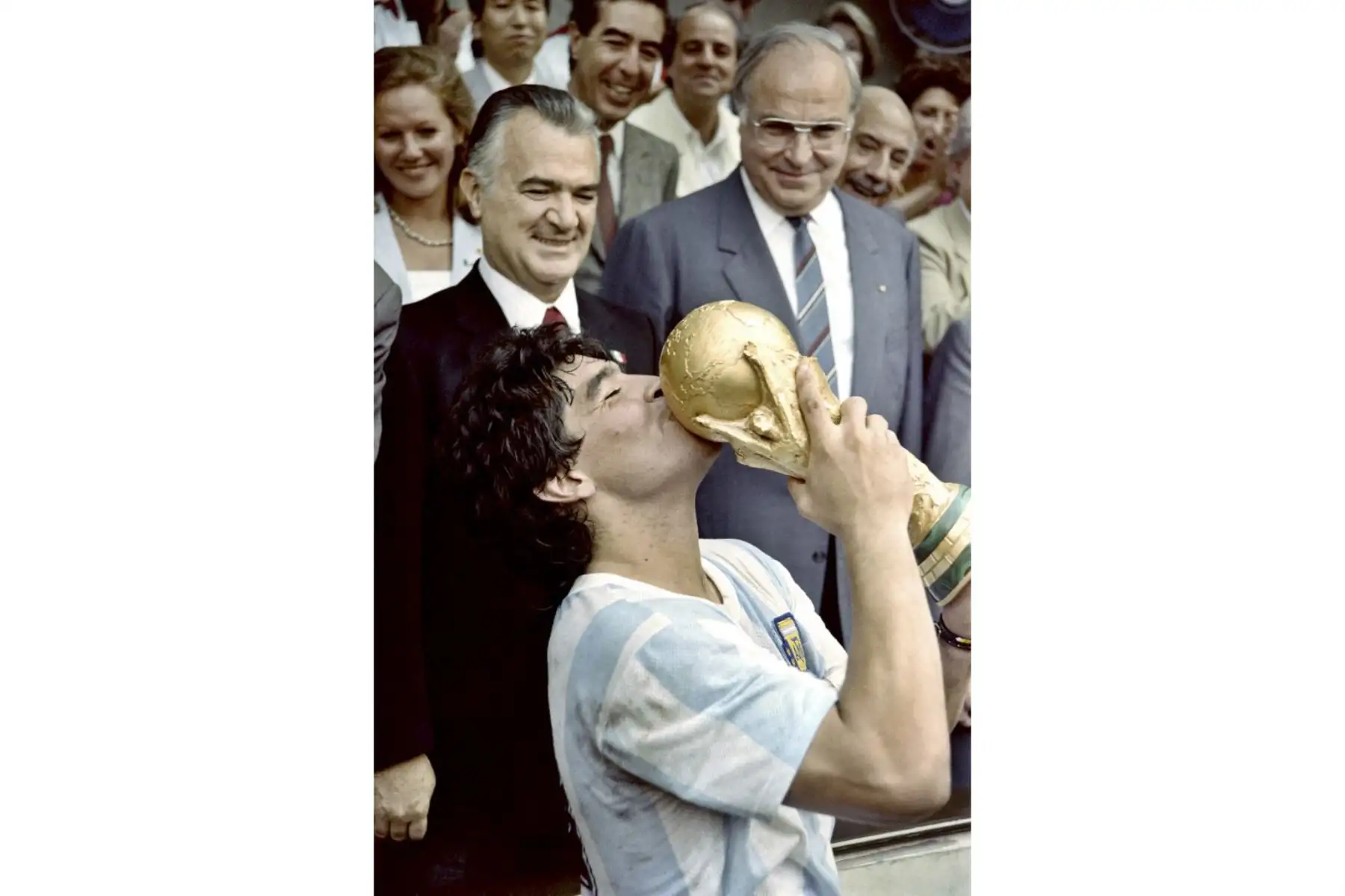 En esta imagen de archivo tomada el 29 de junio de 1986, el capitán del equipo estrella del fútbol argentino Diego Maradona besa la Copa Mundial de Fútbol ganada por su equipo luego de una victoria por 3-2 sobre Alemania Occidental en el estadio Azteca de la Ciudad de México ante el presidente mexicano Miguel. de La Madrid (izq.) y el canciller de Alemania Occidental, Helmut Kohl. Foto: AFP