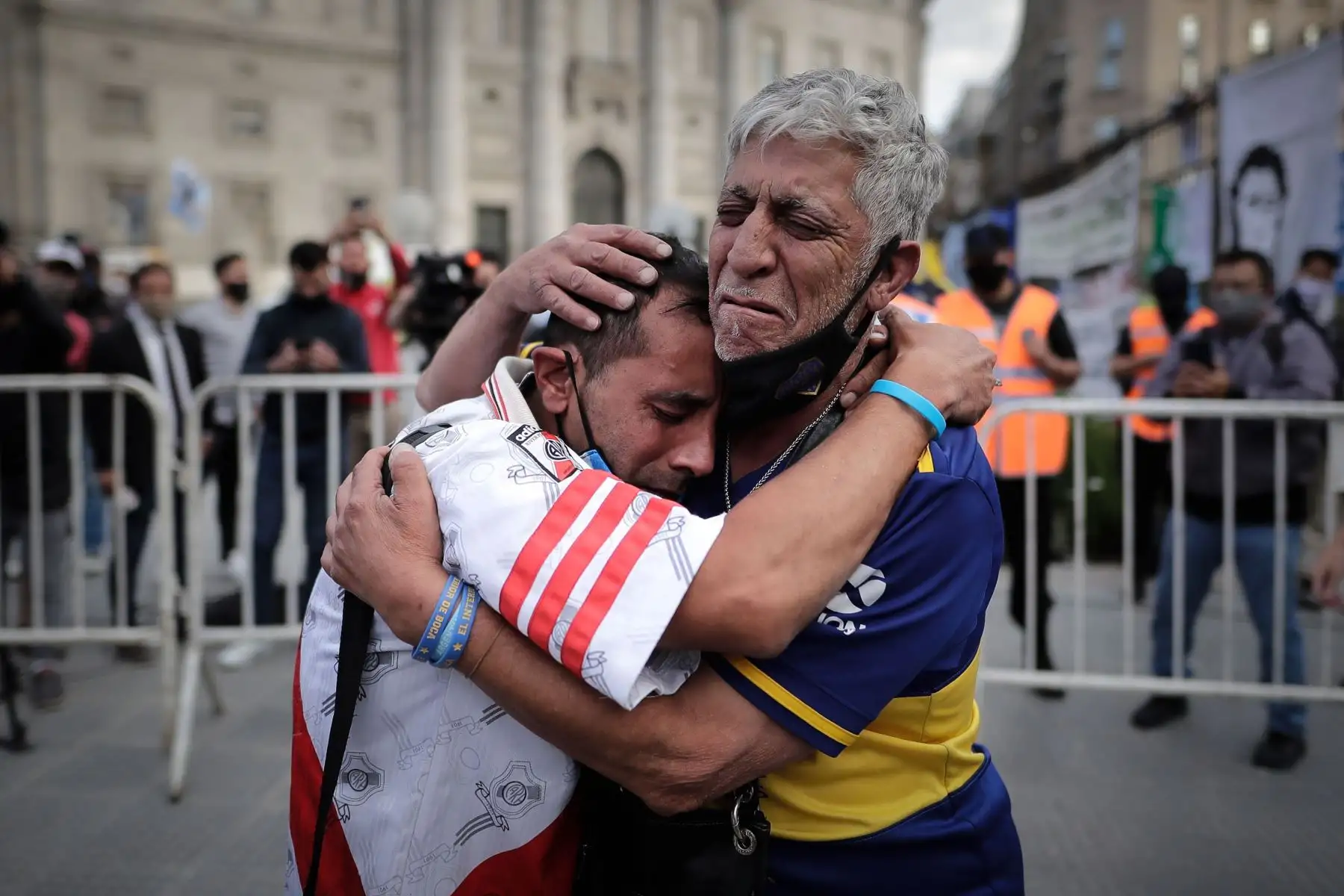 Un aficionado con la camiseta del Boca Juniors y otro con la camiseta del River Plate, se abrazan luego de despedir los restos de Diego Armando Maradona en el velatorio de la capital bonaerense, en la Plaza de Mayo. Foto: EFE
