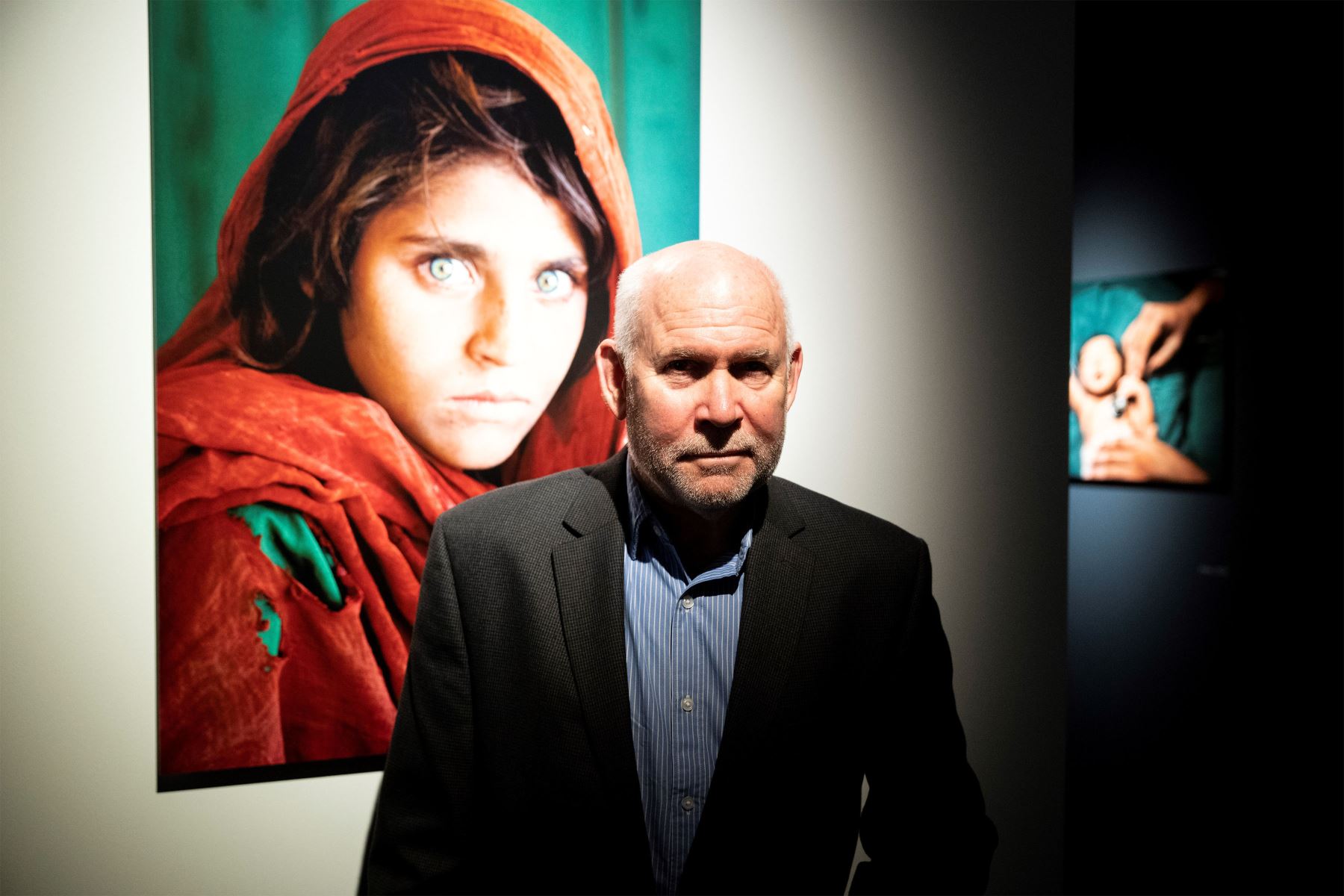 El fotógrafo estadounidense Steve McCurry posa junto a su legendario retrato de la niña afgana Sharbat Gula, que fue portada de National Geographic, durante la presentación de una exposición retrospectiva de su carrera, titulada "Icons".
Foto: EFE