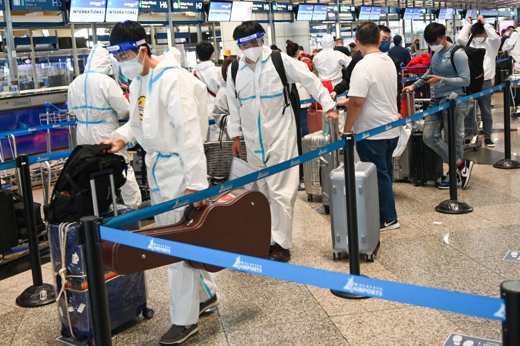 Pasajeros hacen cola para registrarse para su vuelo en el Aeropuerto Internacional de Kuala Lumpur en Sepang, ya que países de todo el mundo cerraron las fronteras y renovaron las restricciones de viaje en respuesta a la propagación de una nueva variación del coronavirus Covid-19 fuertemente mutada denominada Omicron. Foto: AFP