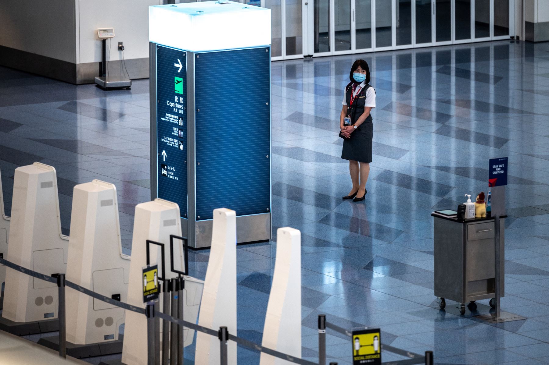 Un miembro del personal espera en una sala de salidas vacía en el aeropuerto internacional Haneda de Tokio. Foto: AFP