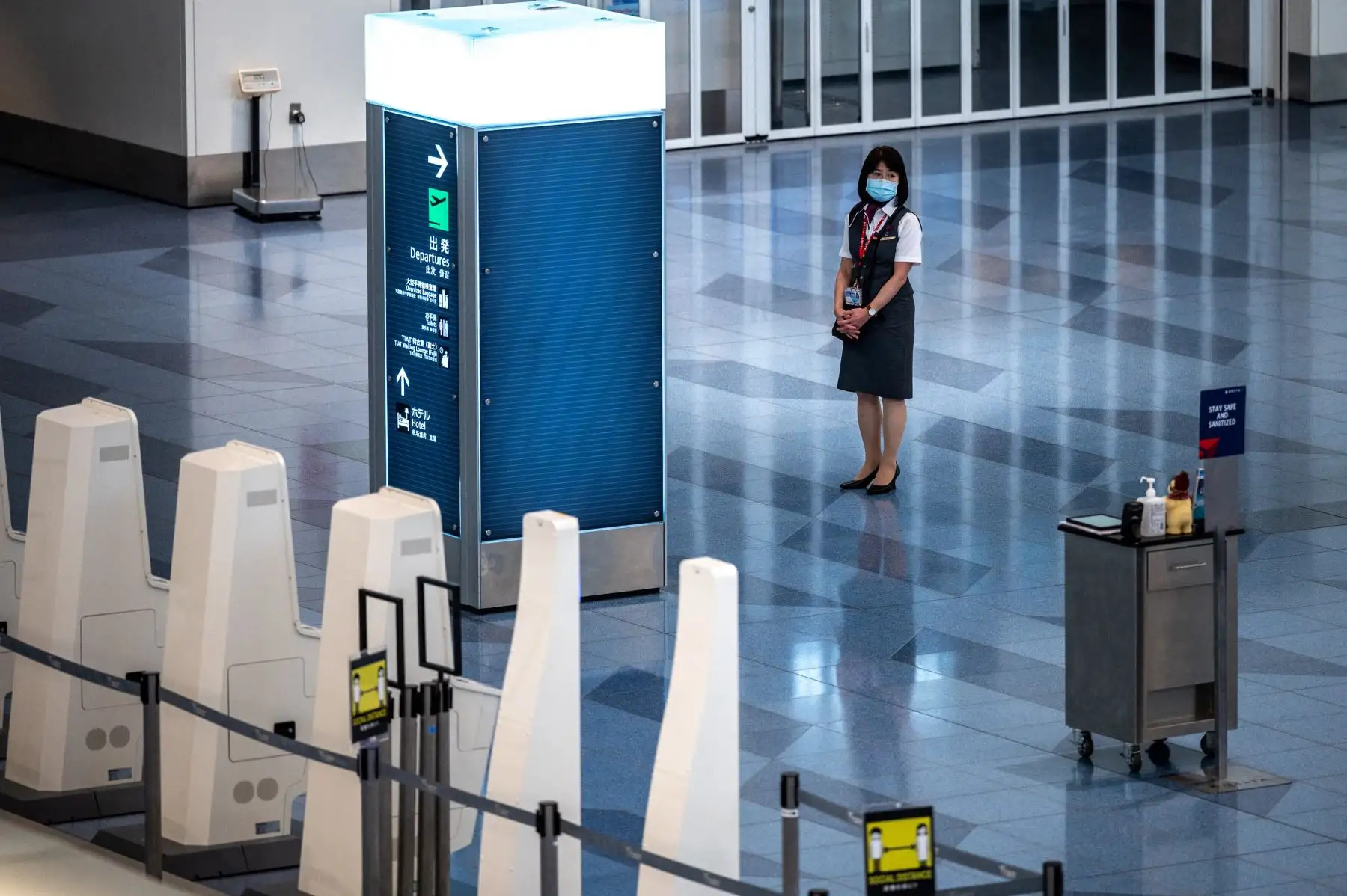 Un miembro del personal espera en una sala de salidas vacía en el aeropuerto internacional Haneda de Tokio. Foto: AFP
