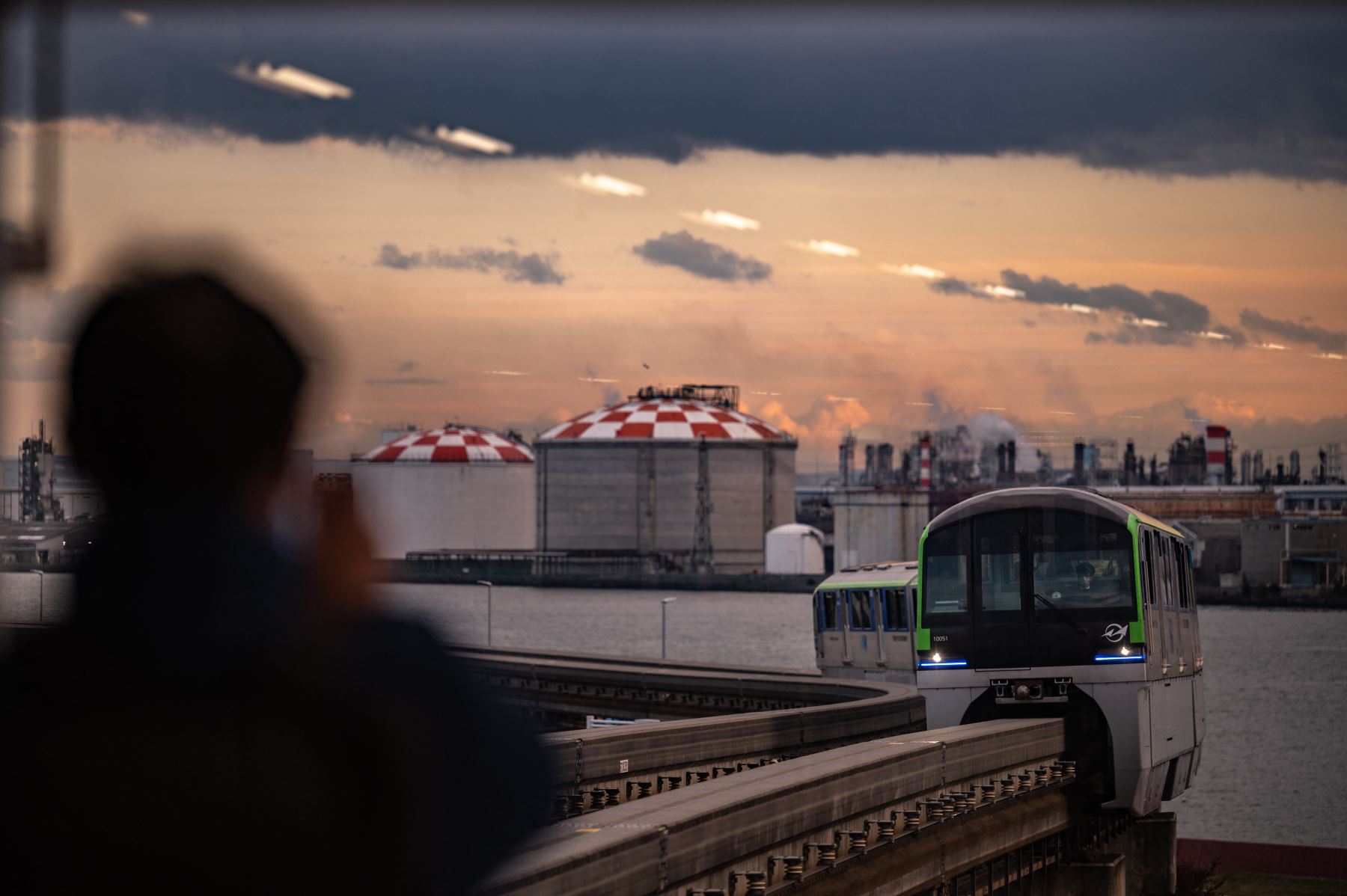 Un hombre toma fotografías del tren de la línea del aeropuerto Haneda del monorraíl de Tokio, un día después de que Japón anunciara que restablecería las estrictas medidas fronterizas, salvo las nuevas llegadas extranjeras por la nueva variante ómicron Covid. Foto: AFP