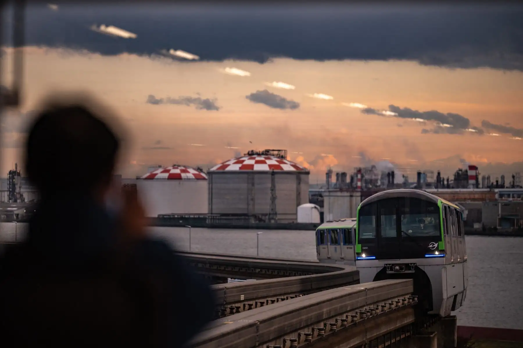 Un hombre toma fotografías del tren de la línea del aeropuerto Haneda del monorraíl de Tokio, un día después de que Japón anunciara que restablecería las estrictas medidas fronterizas, salvo las nuevas llegadas extranjeras por la nueva variante ómicron Covid. Foto: AFP