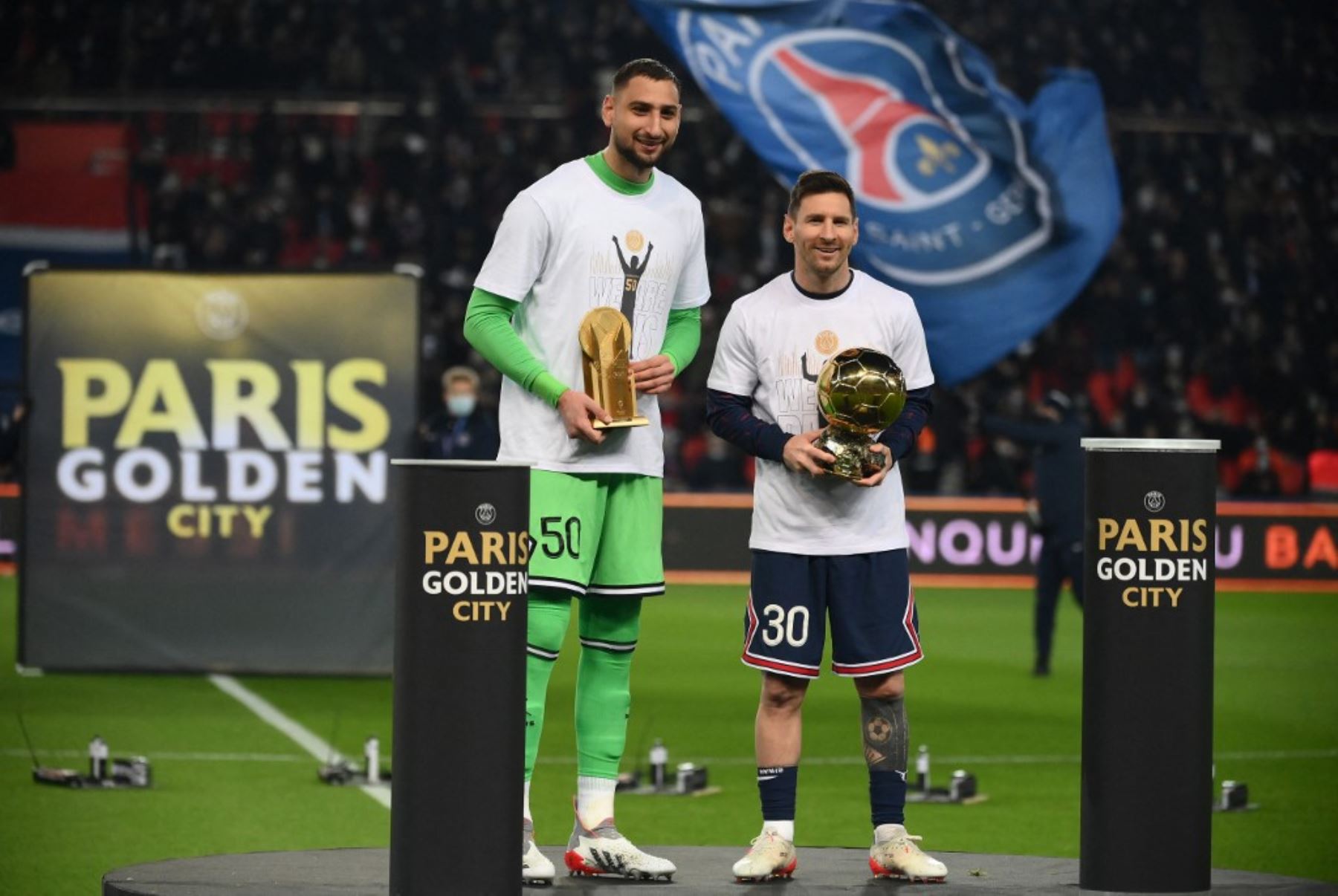 Lionel Messi y Gianluigi Donnarumma muestran sus trofeos ante la hinchada del PSG