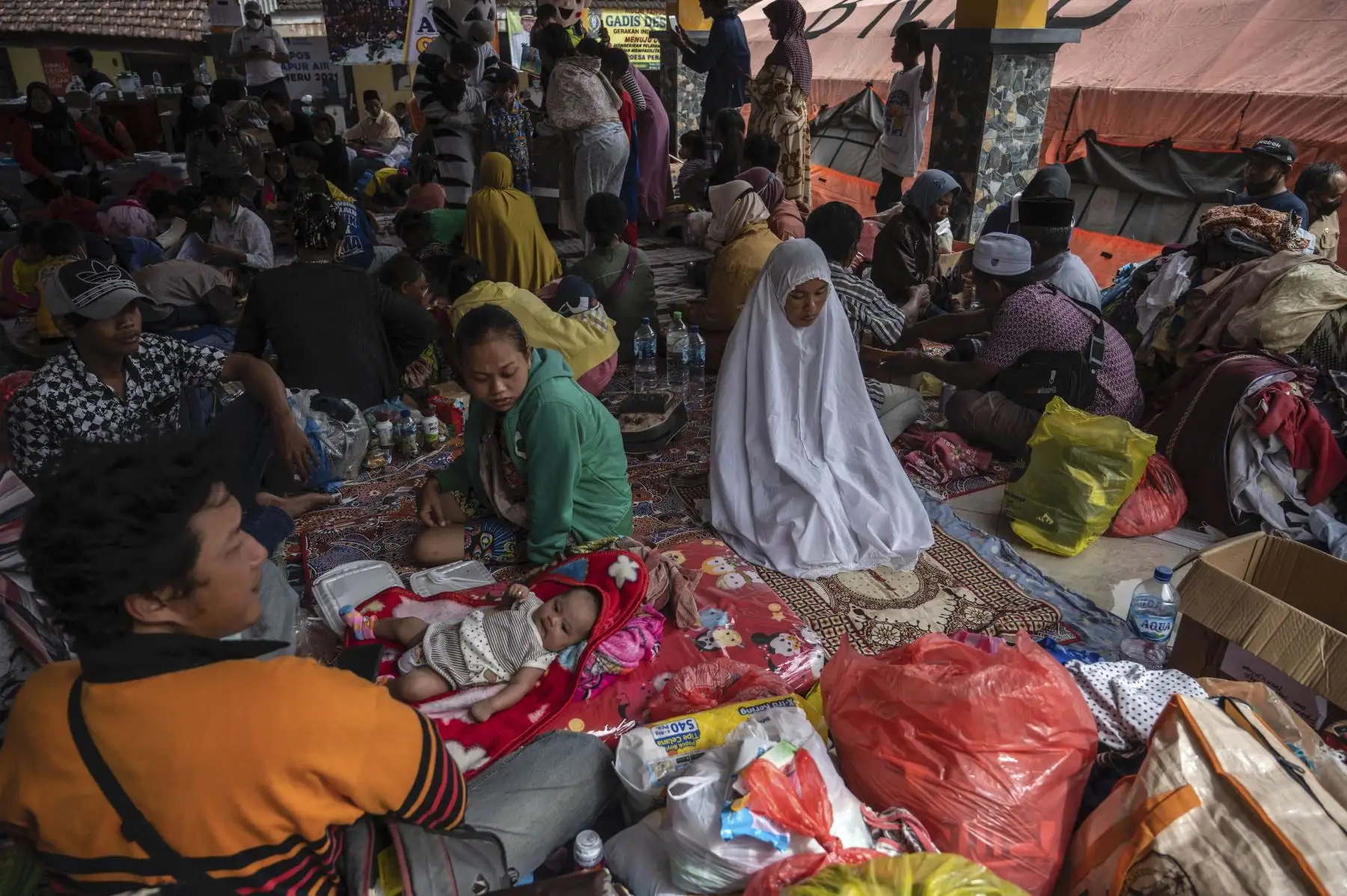 Los aldeanos se reúnen en un refugio improvisado en la aldea de Sumber Wuluh en Lumajang el 6 de diciembre de 2021, después de la erupción del volcán Semeru que mató al menos a 15 personas. Foto: AFP