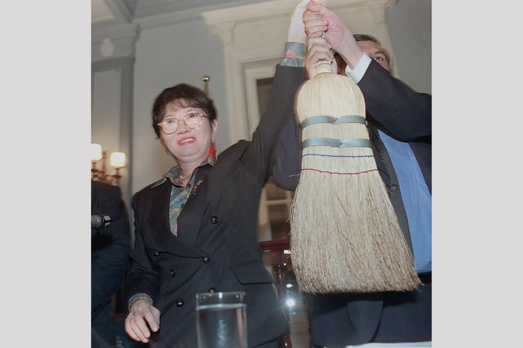 Susana Higuchi,  exesposa del presidente peruano Alberto Fujimori, levanta una escoba simbólica con miembros del  partido Frente Independiente Moralizador (FIM) durante una conferencia de prensa en Lima el 10 de enero de 2000 en vista de las próximas elecciones generales del país. Higuchi  se postulará para un escaño en el parlamento.Foto: AFP