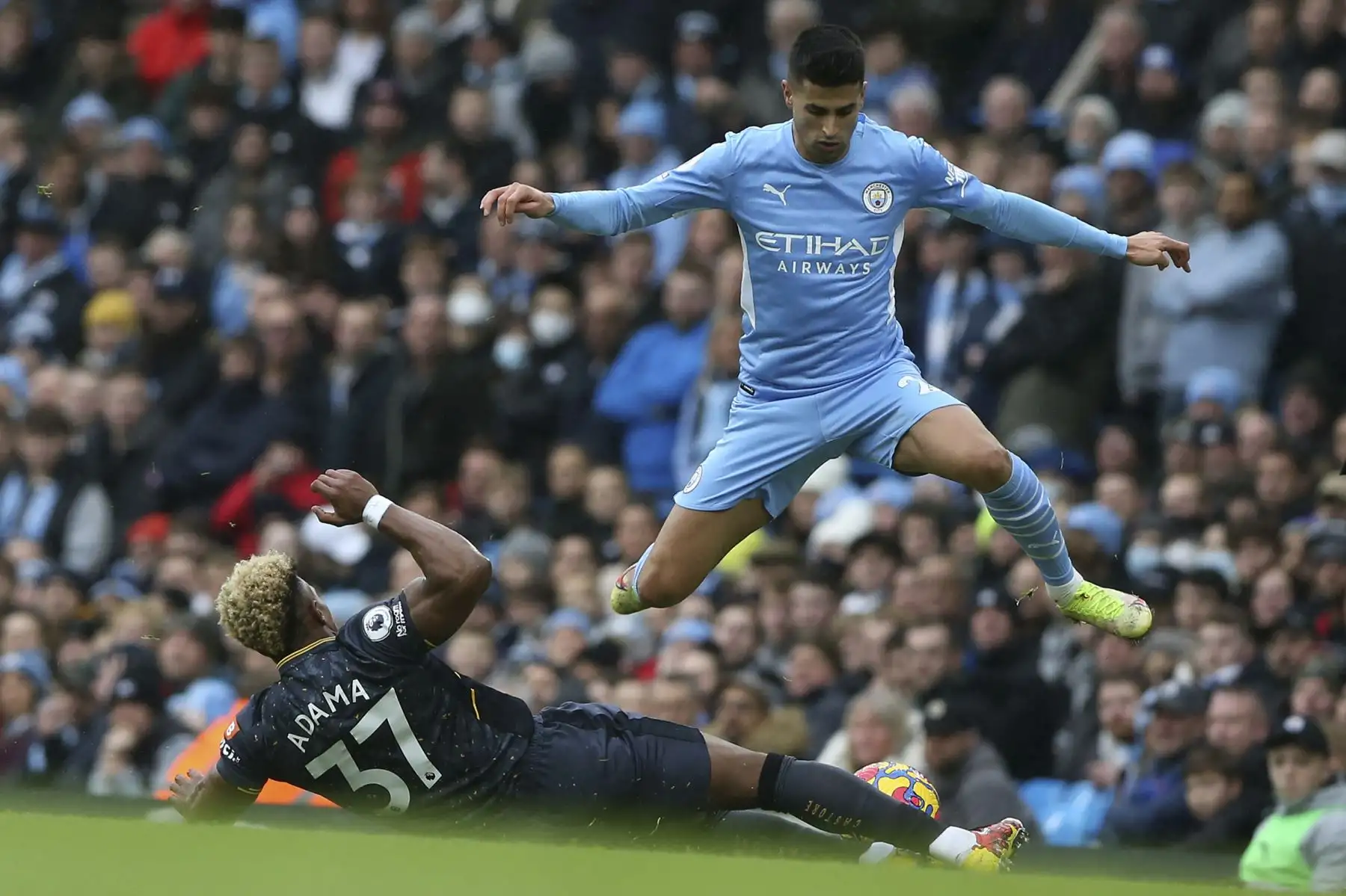 El defensor portugués del Manchester City, Joao Cancelo, salta sobre el mediocampista español del Wolverhampton Wanderers, Adama Traore, durante el partido de la Premier League. Foto: AFP