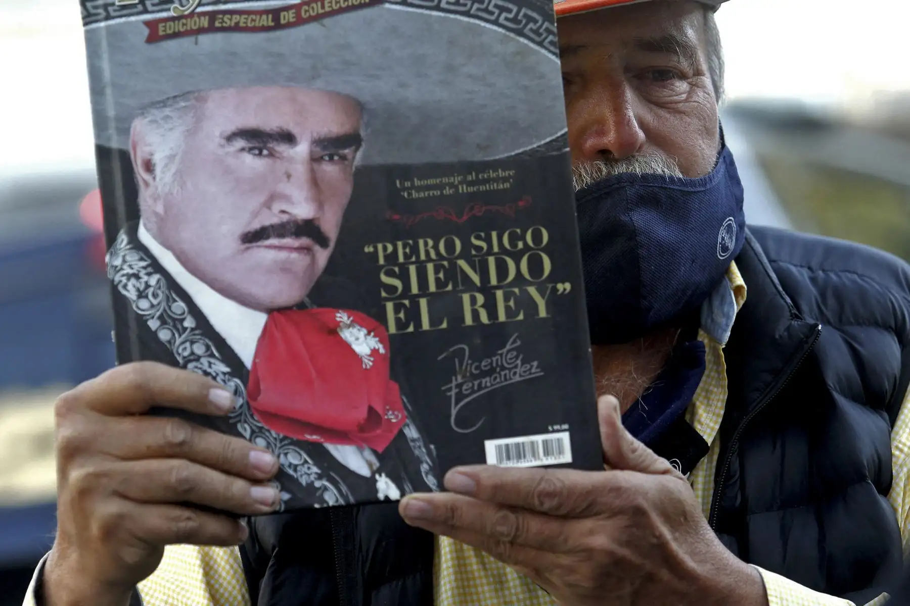Miguel del Toro, de 65 años, muestra un libro sobre la vida del cantante mexicano Vicente Fernández fuera del hospital Country 2000 en Guadalajara, México. Foto: AFP