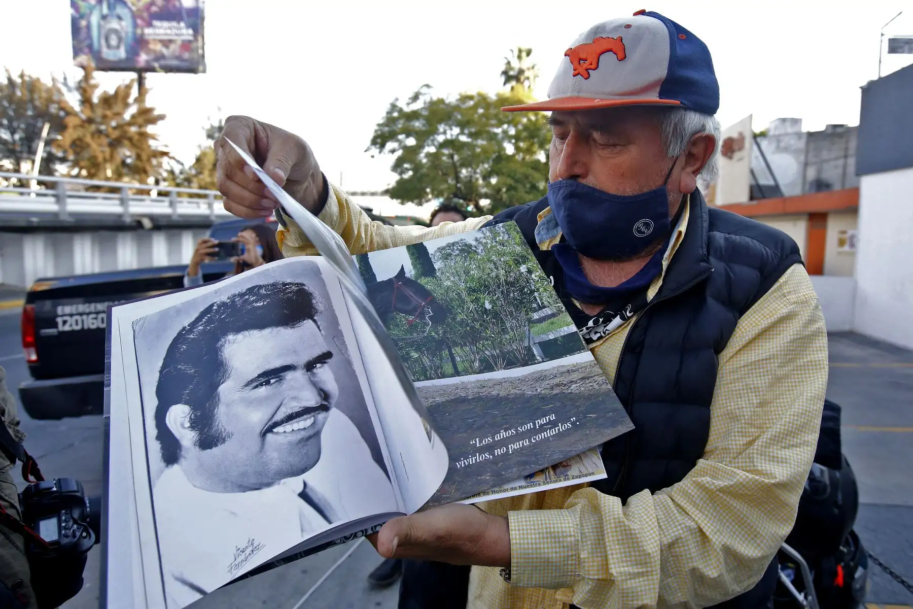 Miguel del Toro, de 65 años, muestra un libro sobre la vida del cantante mexicano Vicente Fernández fuera del hospital Country 2000 en Guadalajara, México. Foto: AFP