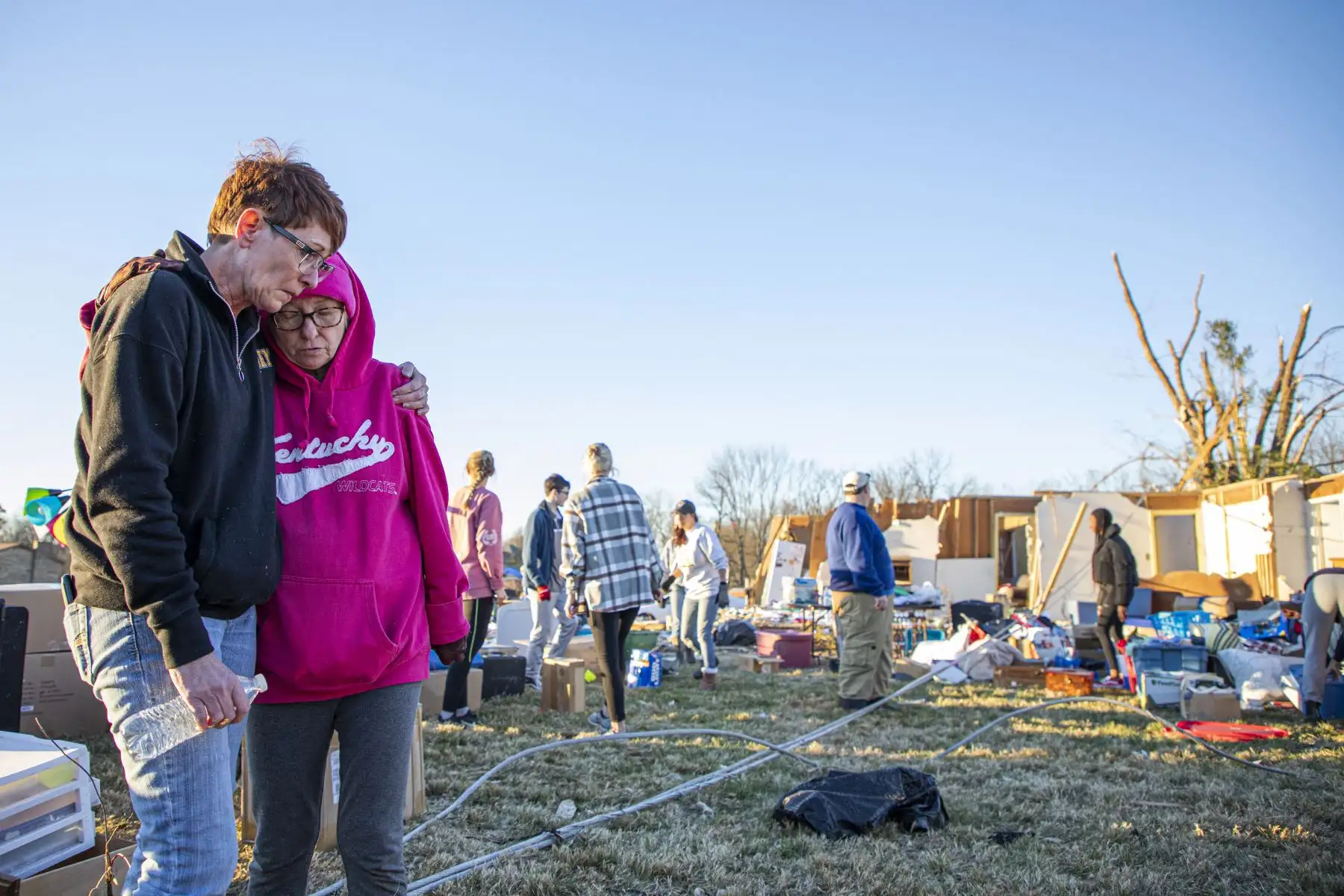 Kitty Williams (derecha) es consolada por su hijastra Kristina Wise (izquierda) frente a lo que queda de su casa después de que el clima extremo azotara el área, en Bowling Green, Kentucky, el 13 de diciembre de 2021. - Funcionarios de Kentucky expresaron alivio el lunes de que decenas de trabajadores en una fábrica de velas parecen haber sobrevivido a tornados que mataron al menos a 88 personas y dejaron un rastro de devastación en seis estados de EE. UU. Foto: AFP