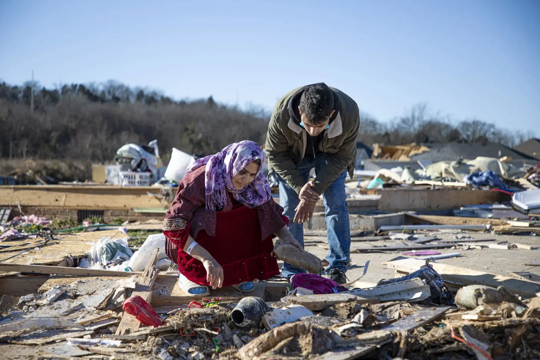 Muhammad Raad ayuda a la madre de su amiga a clasificar lo que queda de sus pertenencias después de que el clima extremo azotara el área, en Bowling Green, Kentucky, el 13 de diciembre de 2021. Foto: AFP