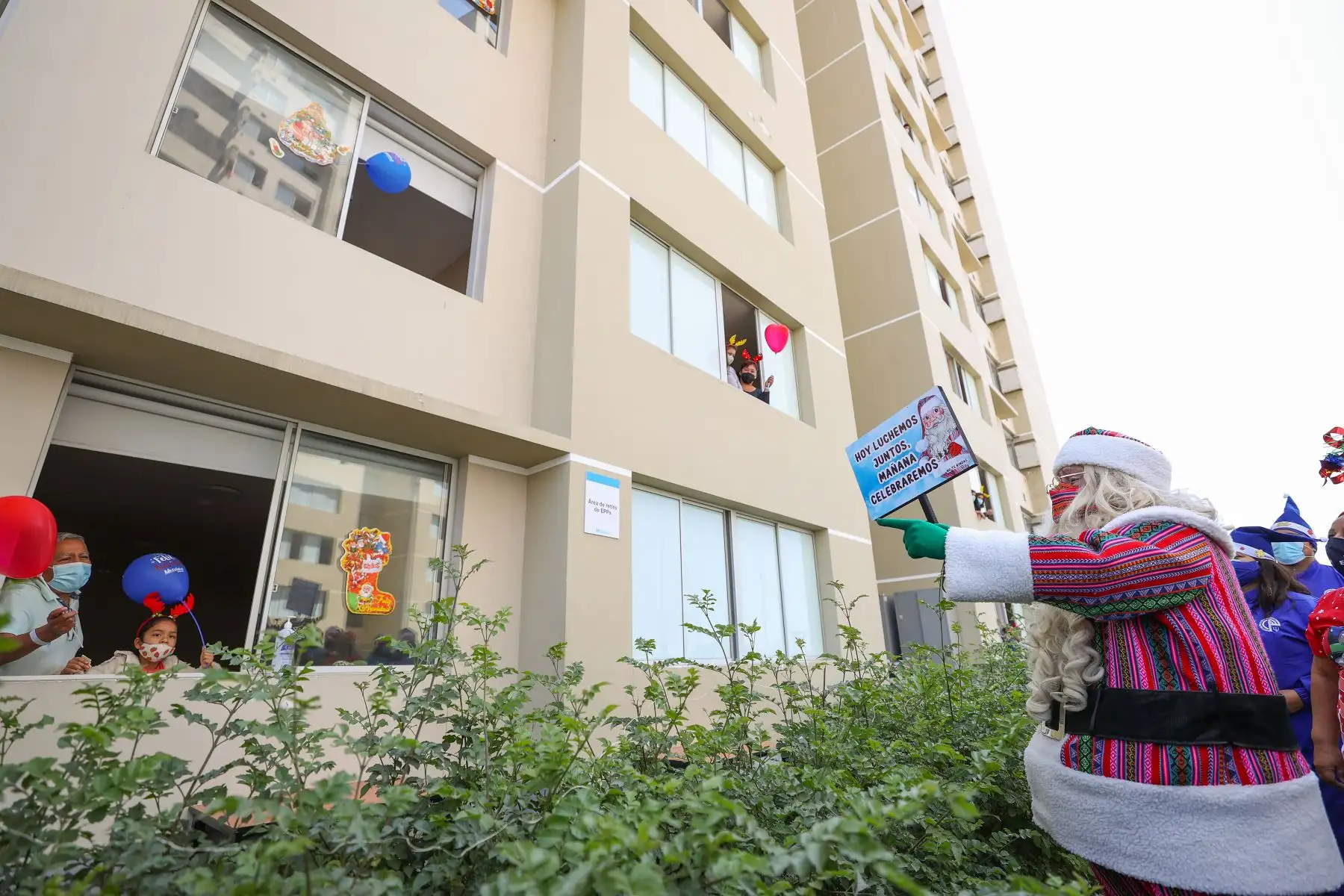 A pocos días de celebrarse la Navidad, Paul Suarez, el Papá Noel peruano, visitó la Villa Panamericana para llevar magia, color y alegría a más de 120 niños con Covid-19 que se encuentran aislados en este centro de atención. Con apoyo de una escalera telescópica de la Compañía de Bomberos, el navideño personaje llegó hasta los pisos más altos de las torres de la Villa para que ningún menor se quede sin obsequio. 
Foto: ANDINA/Jhonel Rodríguez