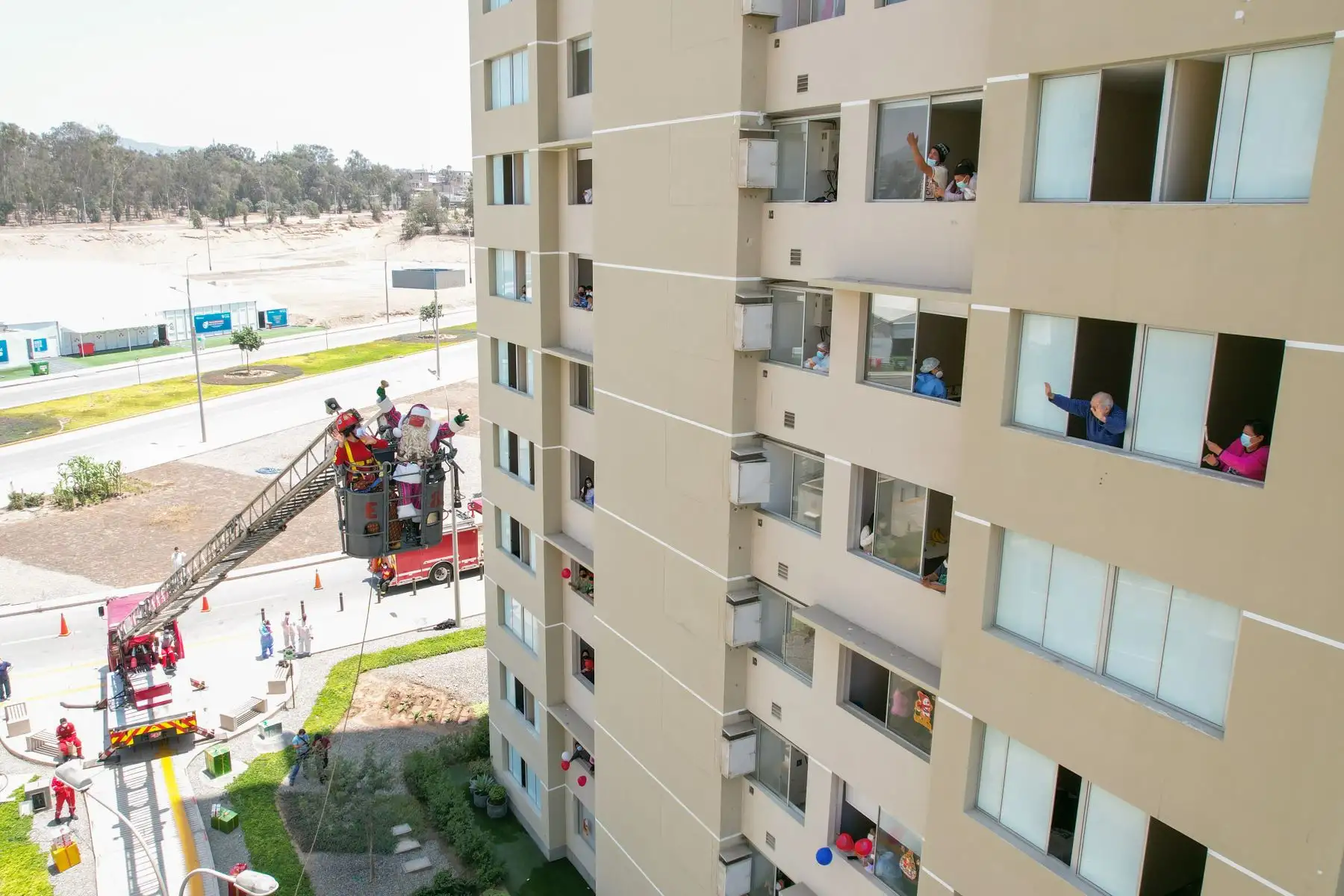 A pocos días de celebrarse la Navidad, Paul Suarez, el Papá Noel peruano, visitó la Villa Panamericana para llevar magia, color y alegría a más de 120 niños con Covid-19 que se encuentran aislados en este centro de atención. Con apoyo de una escalera telescópica de la Compañía de Bomberos, el navideño personaje llegó hasta los pisos más altos de las torres de la Villa para que ningún menor se quede sin obsequio. 
Foto: ANDINA/Jhonel Rodríguez