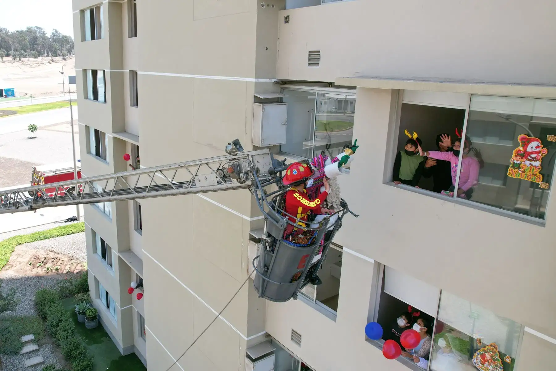 A pocos días de celebrarse la Navidad, Paul Suarez, el Papá Noel peruano, visitó la Villa Panamericana para llevar magia, color y alegría a más de 120 niños con Covid-19 que se encuentran aislados en este centro de atención. Con apoyo de una escalera telescópica de la Compañía de Bomberos, el navideño personaje llegó hasta los pisos más altos de las torres de la Villa para que ningún menor se quede sin obsequio. 
Foto: ANDINA/Jhonel Rodríguez