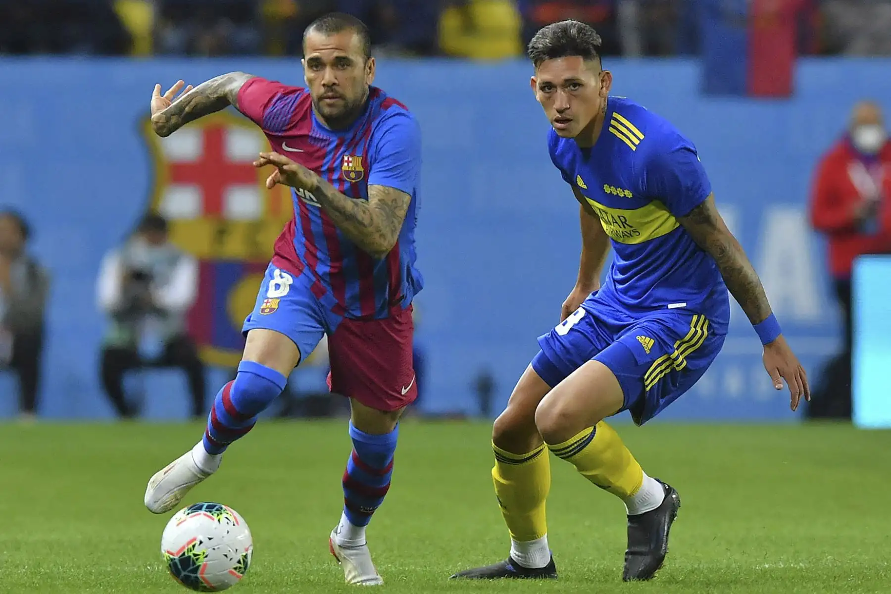 El defensor brasileño de Barcelona Dani Alves (L) compite por el balón con el argentino Boca Juniors Luis Vázquez (R) durante un partido amistoso de fútbol entre el Barcelona de España y el Boca Juniors de Argentina, parte de la Copa Maradona en el estadio Mrsool Park de la capital saudita, Riad, en diciembre 14, 2021 Foto: AFP