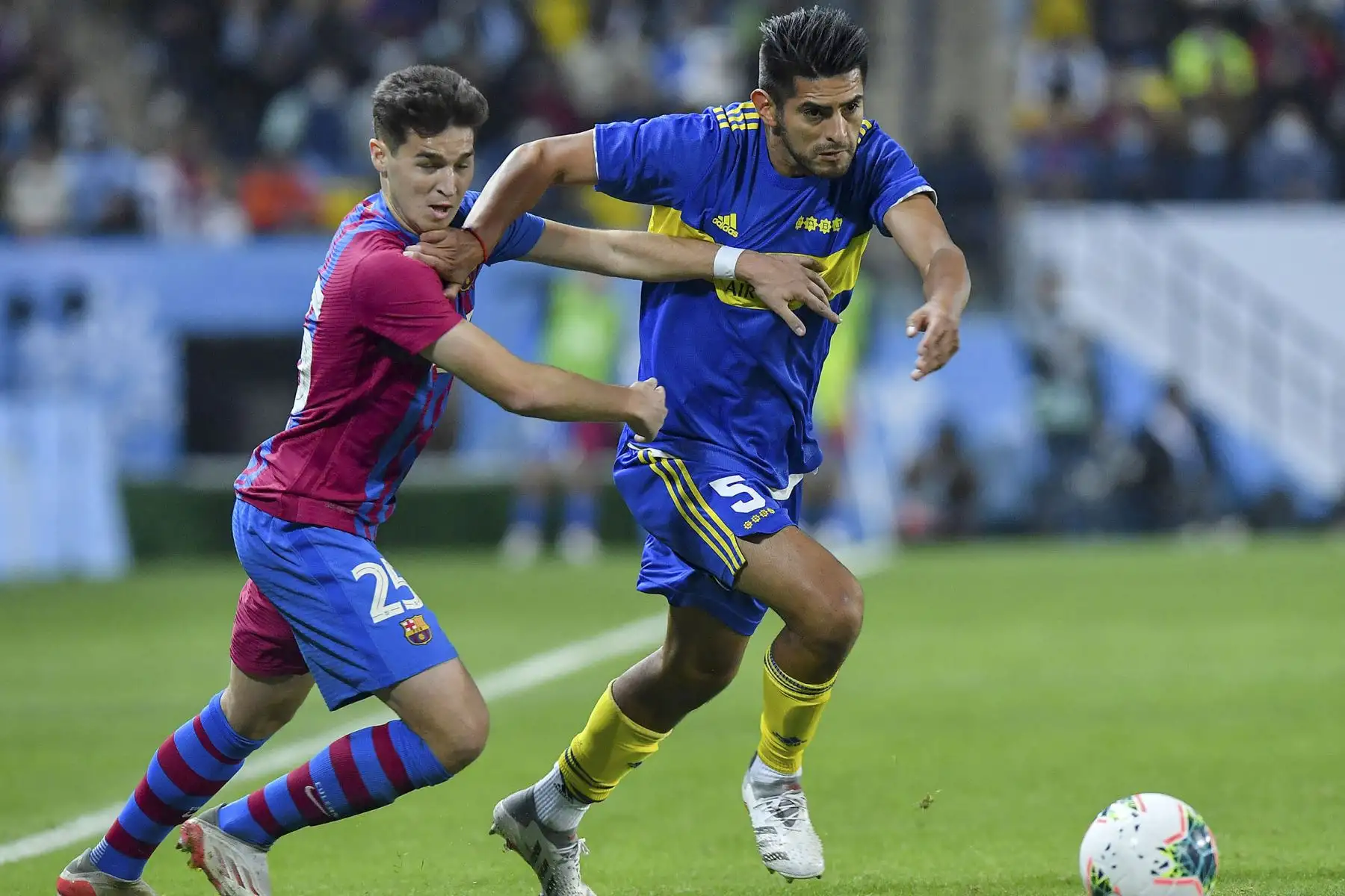 El centrocampista español de Barcelona Mika Marmol Medina (L), y el peruano Carlos Zambrano (R) de Boca Juniors, luchan por el balón durante un partido amistoso de fútbol entre el Barcelona de España y el Boca Juniors de Argentina, parte de la Copa Maradona en el estadio Mrsool Park en la capital saudita, Riad. Foto: AFP