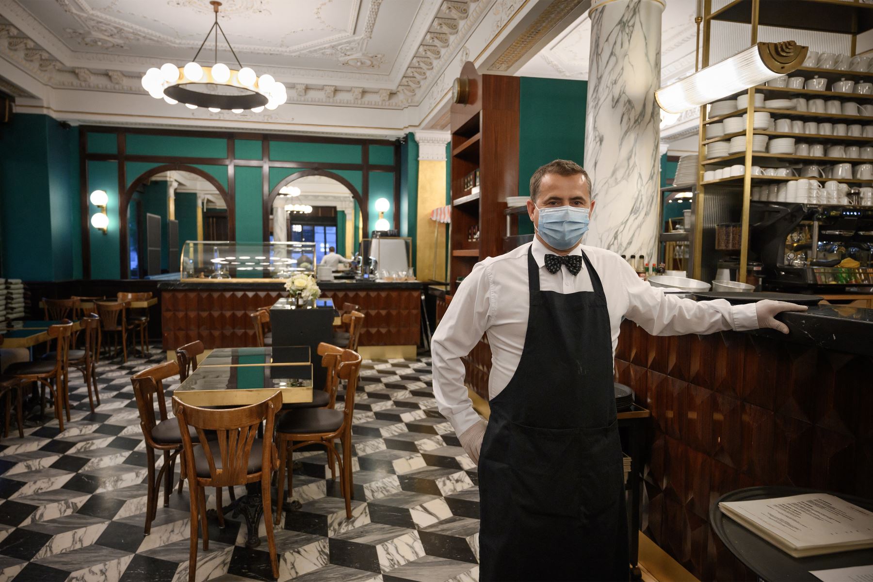 Un camarero con mascarilla posa en el restaurante casi vacío "Le Lyrique cafe brasserie" en Ginebra, a última hora del 12 de mayo del 2020. Foto: AFP/Archivo