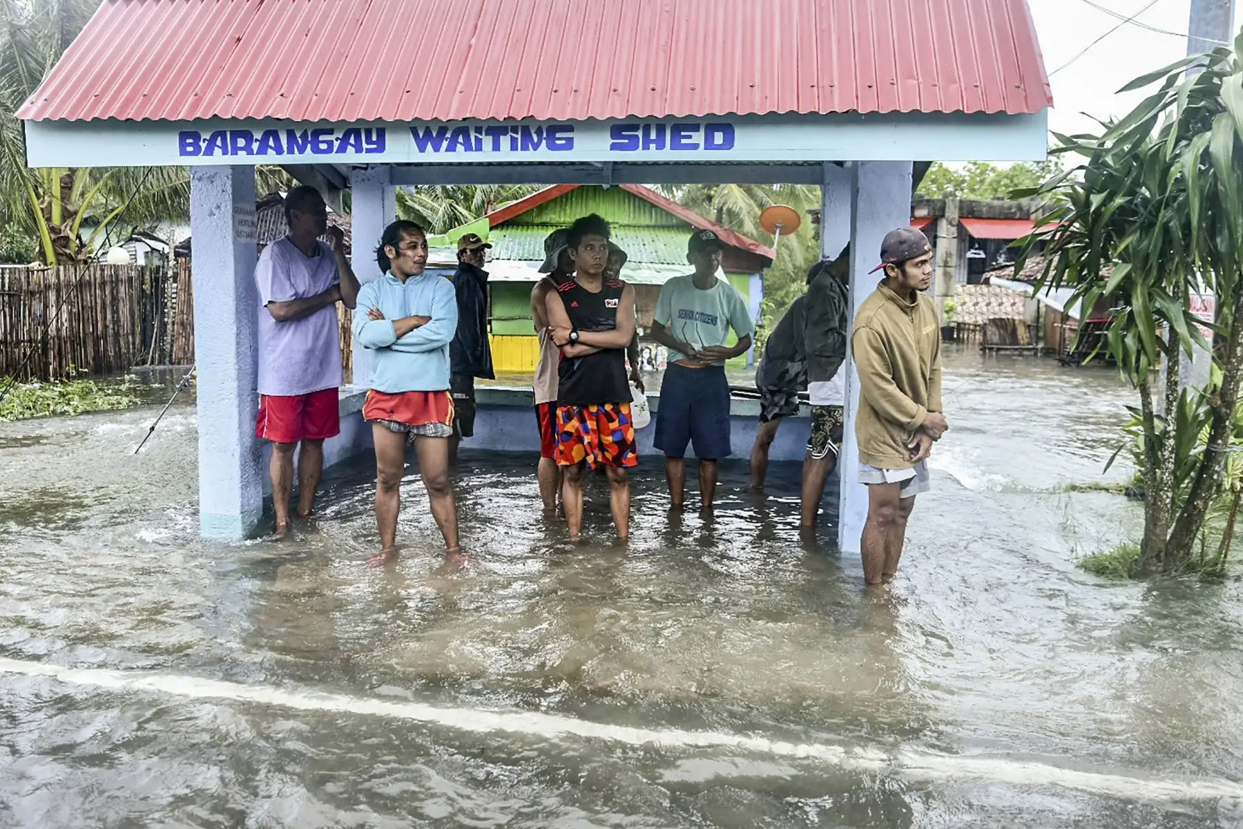 Residentes observan los trabajos de apoyo en una zona inundada en la ciudad costera de Guiuan, provincia de Samar Oriental, en el centro de Filipinas. Foto: AFP