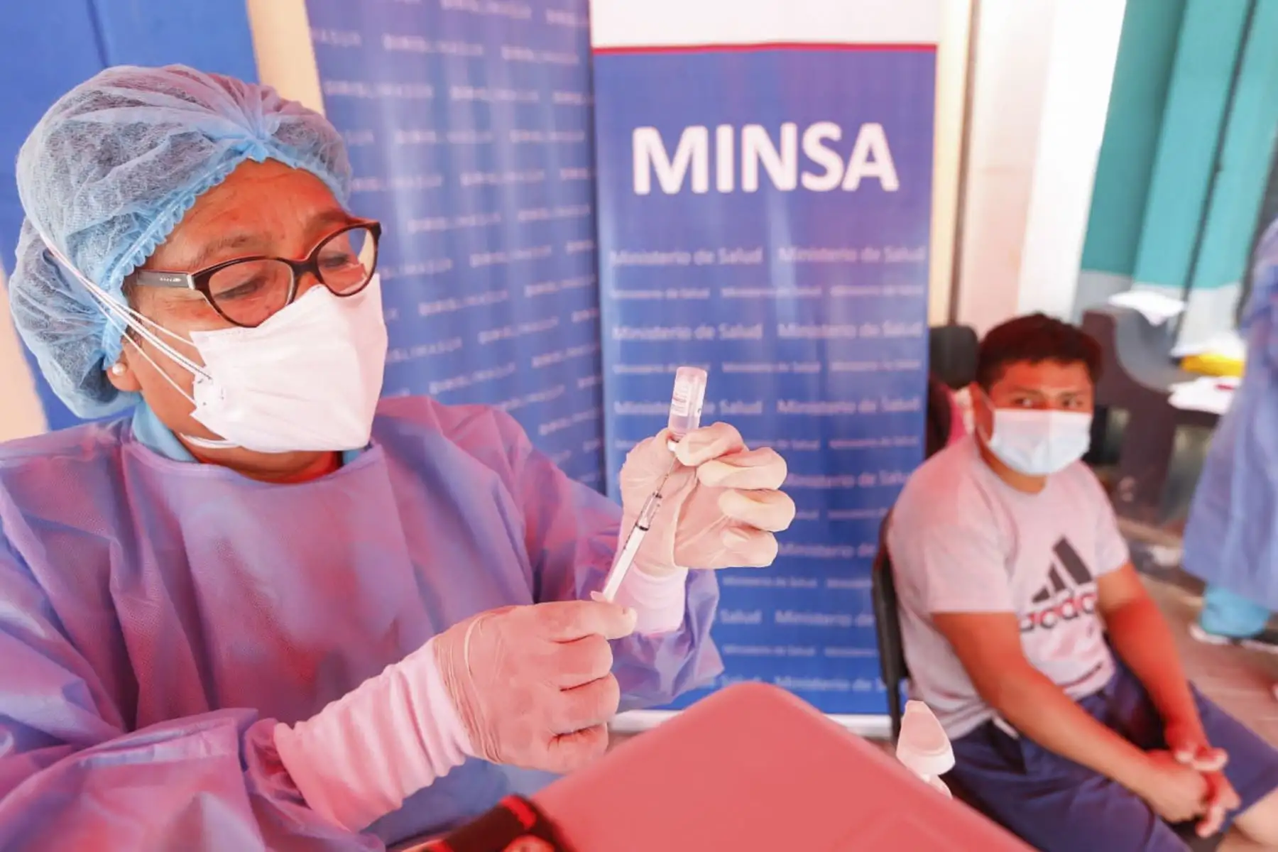 El ministro de Salud, Hernando Cevallos, supervisa la vacunación de adultos mayores que acuden al Banco de la Nación de Villa El Salvador a recibir el bono. Foto: Minsa