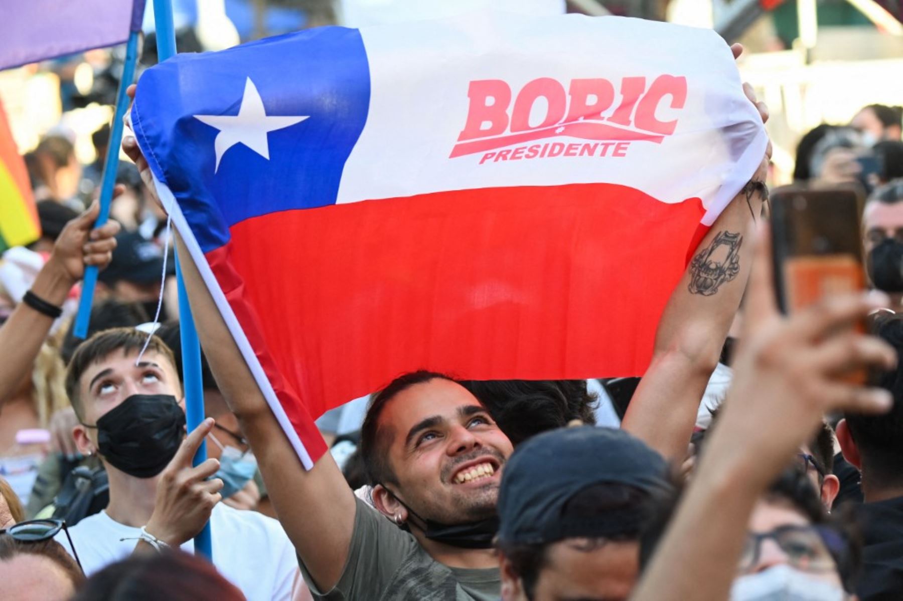 Simpatizantes del candidato presidencial chileno Gabriel Boric, del partido Apruebo Dignidad, celebran tras los primeros resultados oficiales de la segunda vuelta de las elecciones presidenciales, en Santiago, el 19 de diciembre de 2021. Foto: AFP
