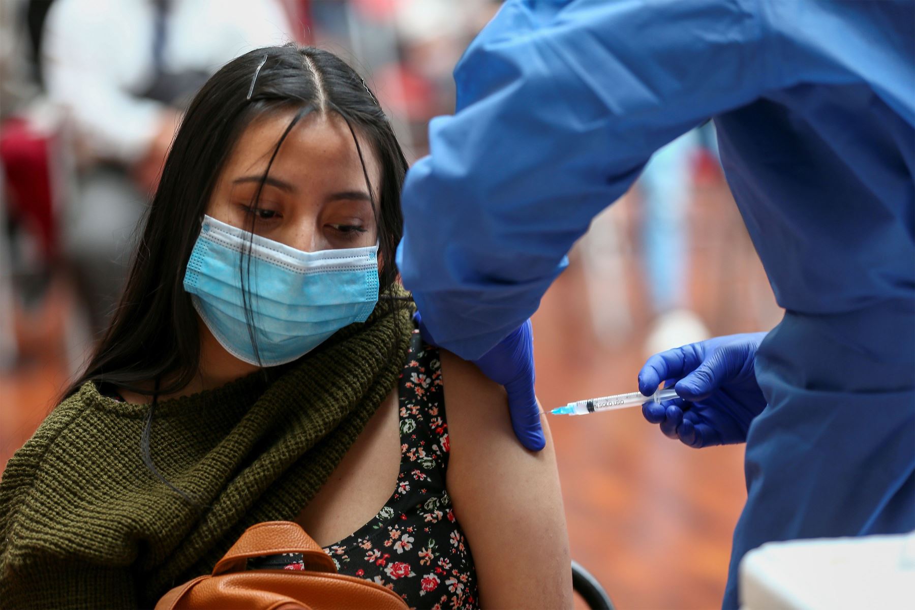 Fotografía de archivo en la que se registró a una joven al ser vacunada contra el covid-19, en la Universidad de Las Américas, en Quito. Foto: EFE