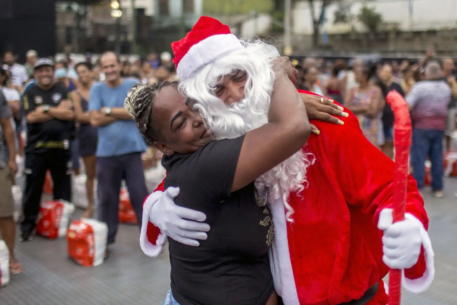 Una mujer abraza a un hombre disfrazado de Papá Noel durante una distribución de comida navideña organizada por la ONG Central ⁄nica das Favelas (CUFA) en el barrio pobre del Complejo Penha, comúnmente conocido como Complejo Alemao, en Río de Janeiro, Brasil, 
Foto: AFP