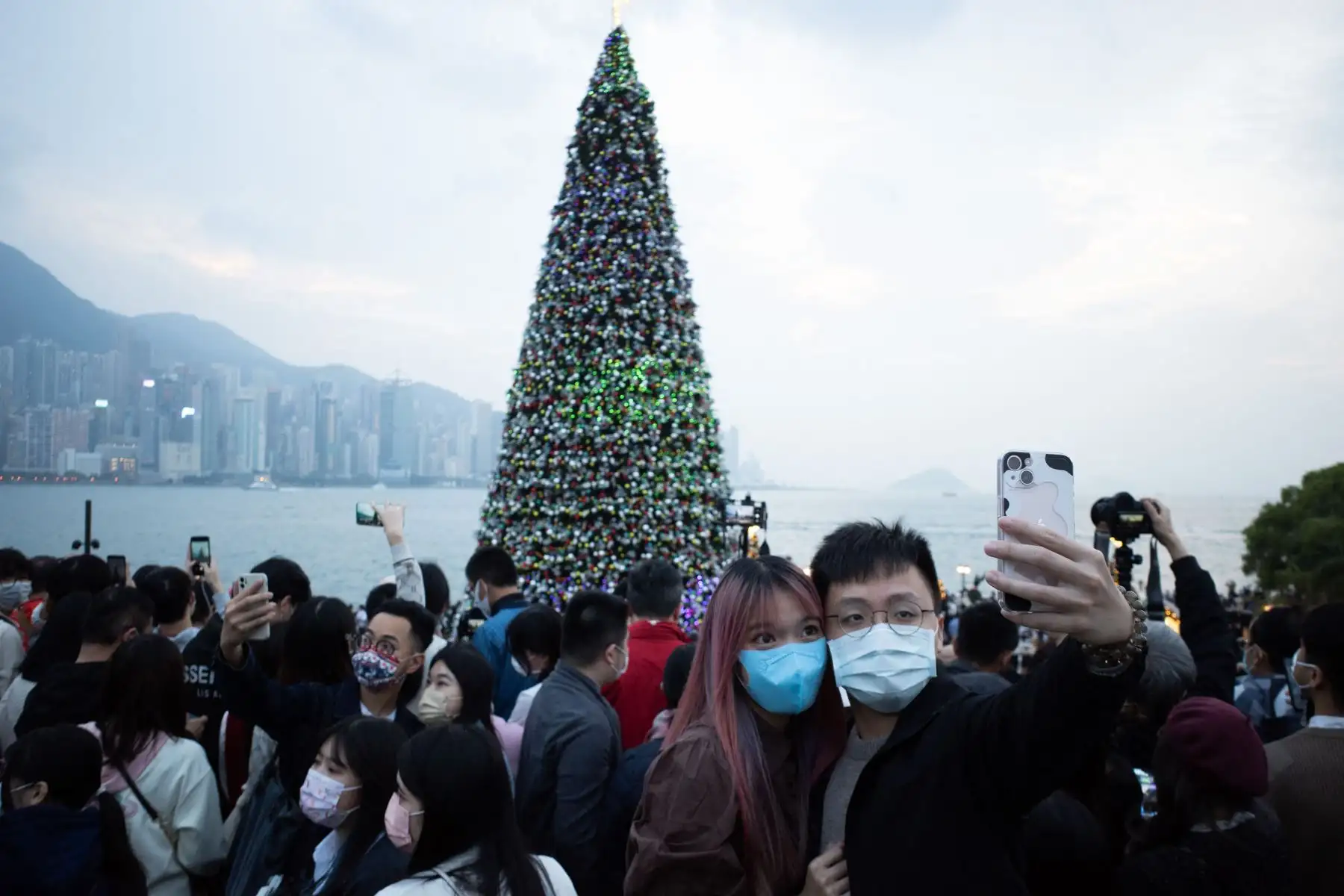 Una pareja posa para una foto frente a un árbol de Navidad gigante durante la Navidad en el distrito cultural de West Kowloon en Hong Kong el 25 de diciembre de 2021.Foto: AFP