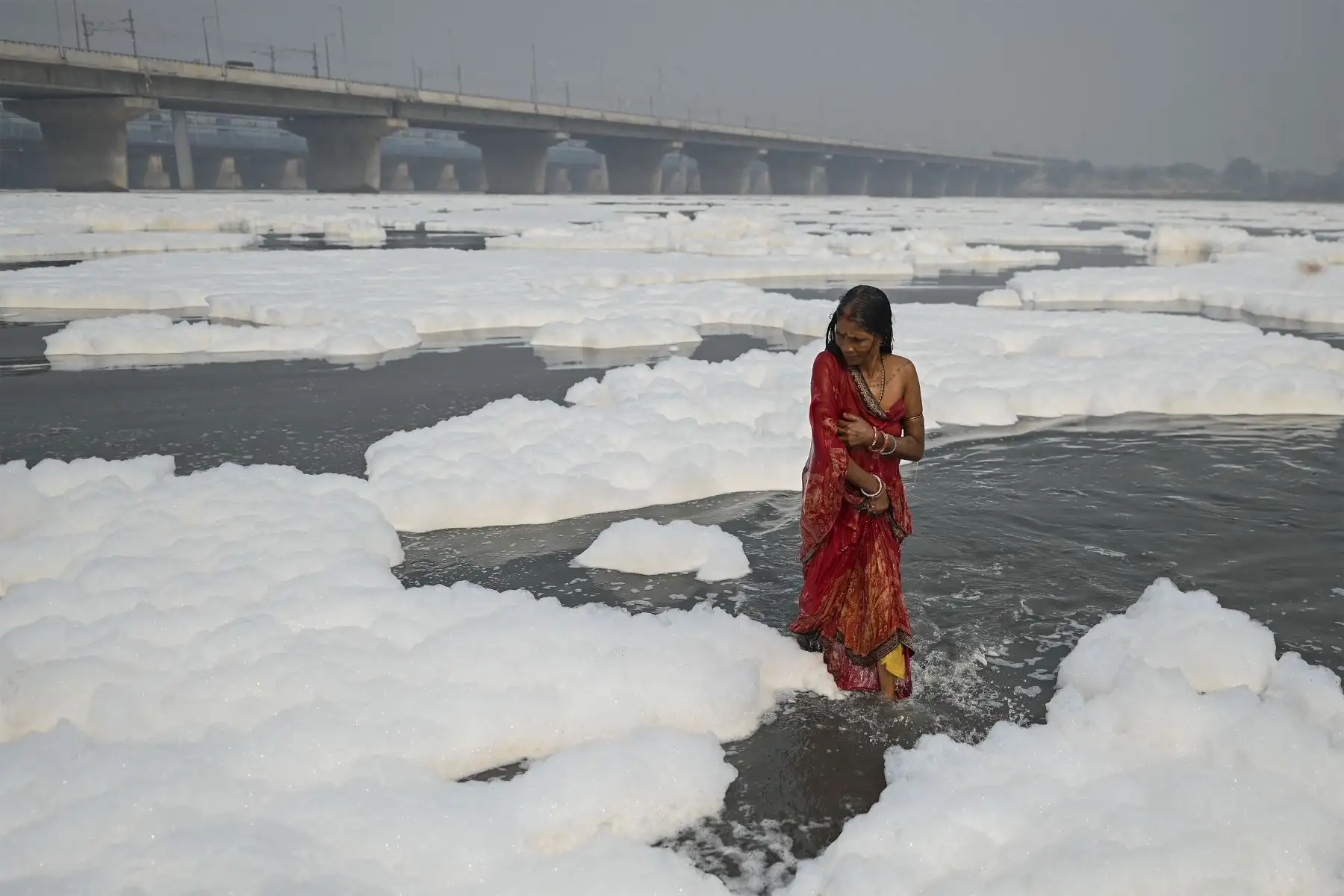 Un devoto se baña en las aguas del río Yamuna como parte de los rituales del próximo festival hindú de Chhat puja en medio de la espuma creada por la contaminación del agua en Nueva Delhi el 8 de noviembre de 2021.
Foto: AFP