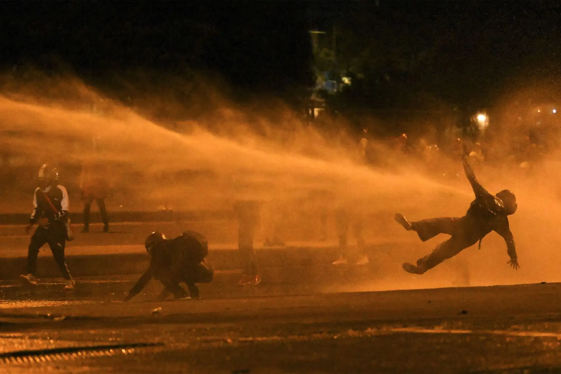 Un manifestante cae al ser alcanzado por un cañón de agua durante los enfrentamientos con la policía antidisturbios en medio de las continuas protestas contra el gobierno del presidente colombiano Iván Duque en Bogotá el 12 de junio de 2021.
Foto: AFP