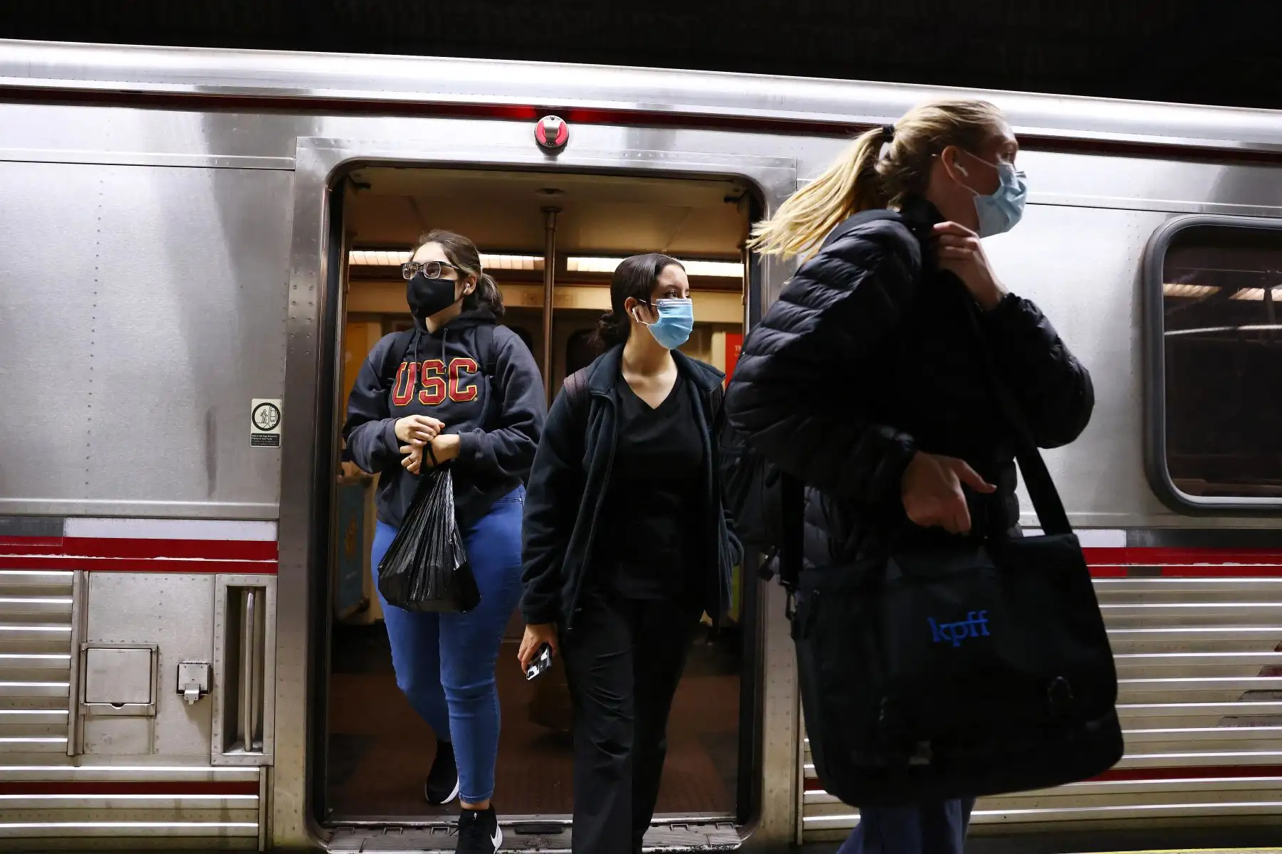 Personas usan cubiertas faciales al salir de un tren Metro Rail en Los Ángeles, California. Foto: AFP
